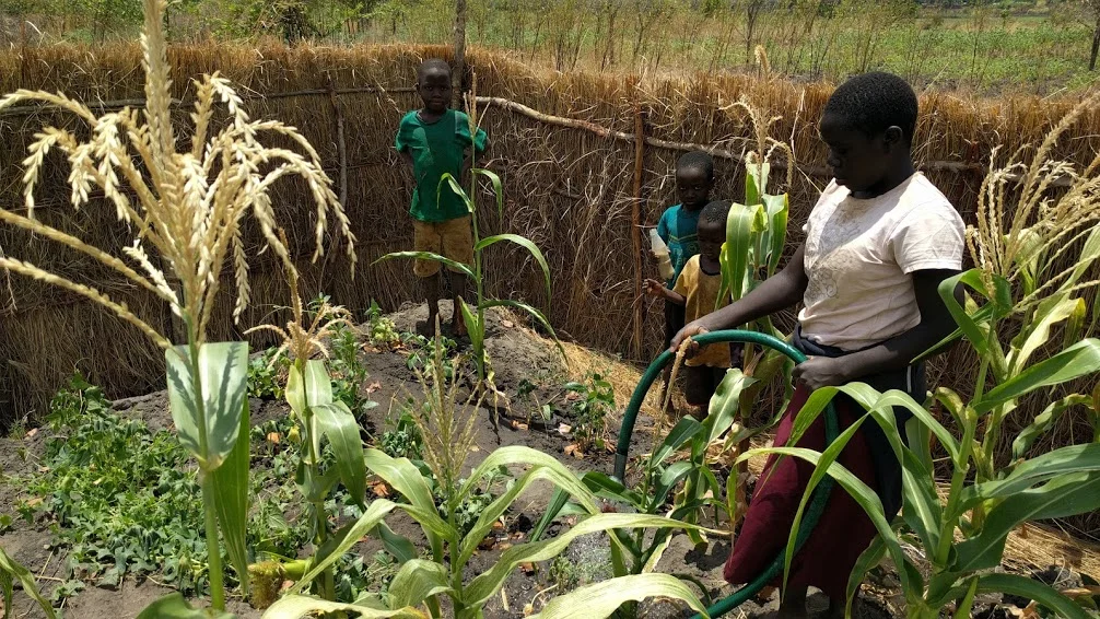 Kambale Makiyi's children are eager to show off the pump! Now that he's making more money he's able to send them to school. 