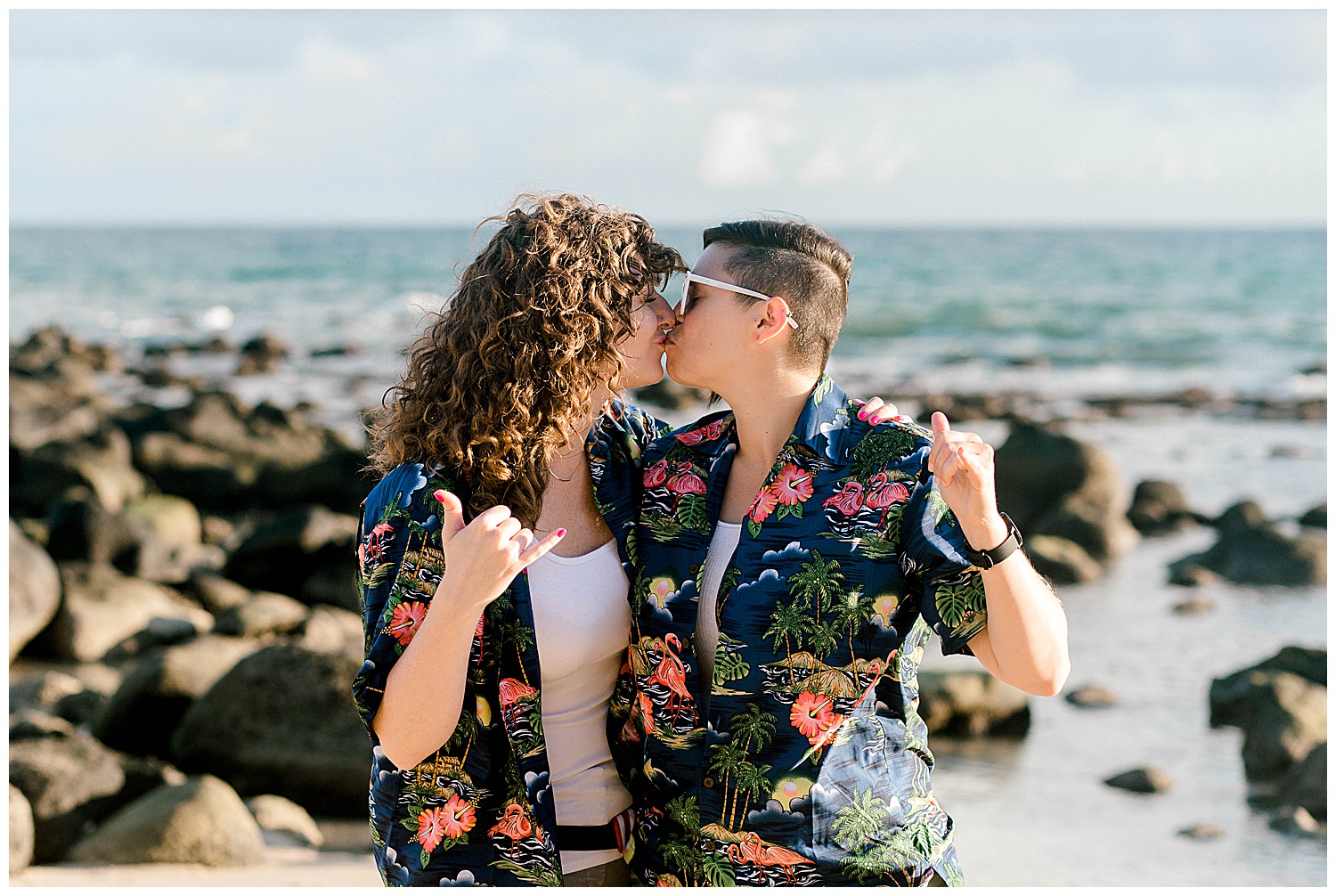 Couple giving the shaka and kissing on Maui beach