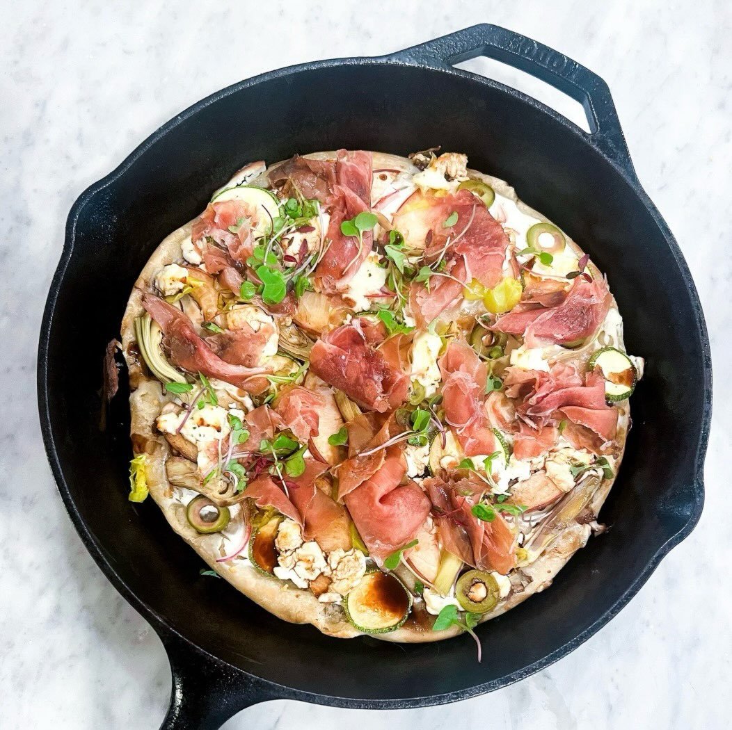 Cast iron pizza... labneh, peaches, prosciutto... what can go wrong?

Ingredients:

20oz pizza dough
avocado oil spray
labneh
3 castelvetrano olives, sliced
1 slice red onion, halved
1 T sliced pepperoncini
1/2 white peach, sliced
3 slices prosciutto
