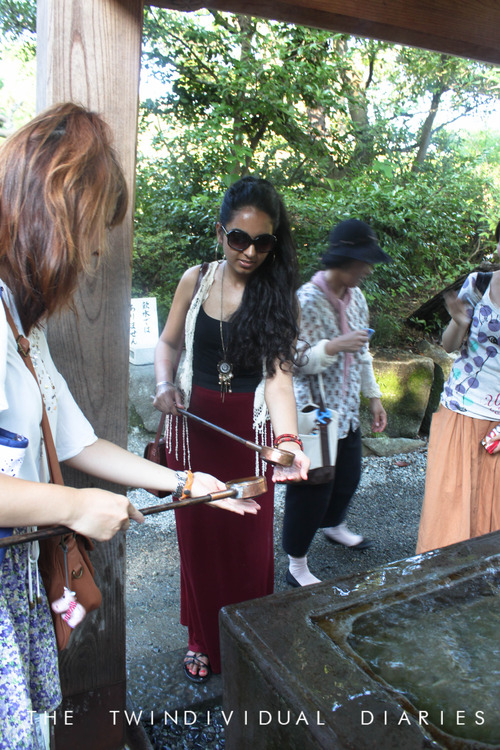 Our host Shiori showing Hernoor how to wash her hands the traditional way, before we go and see Buddha. 
