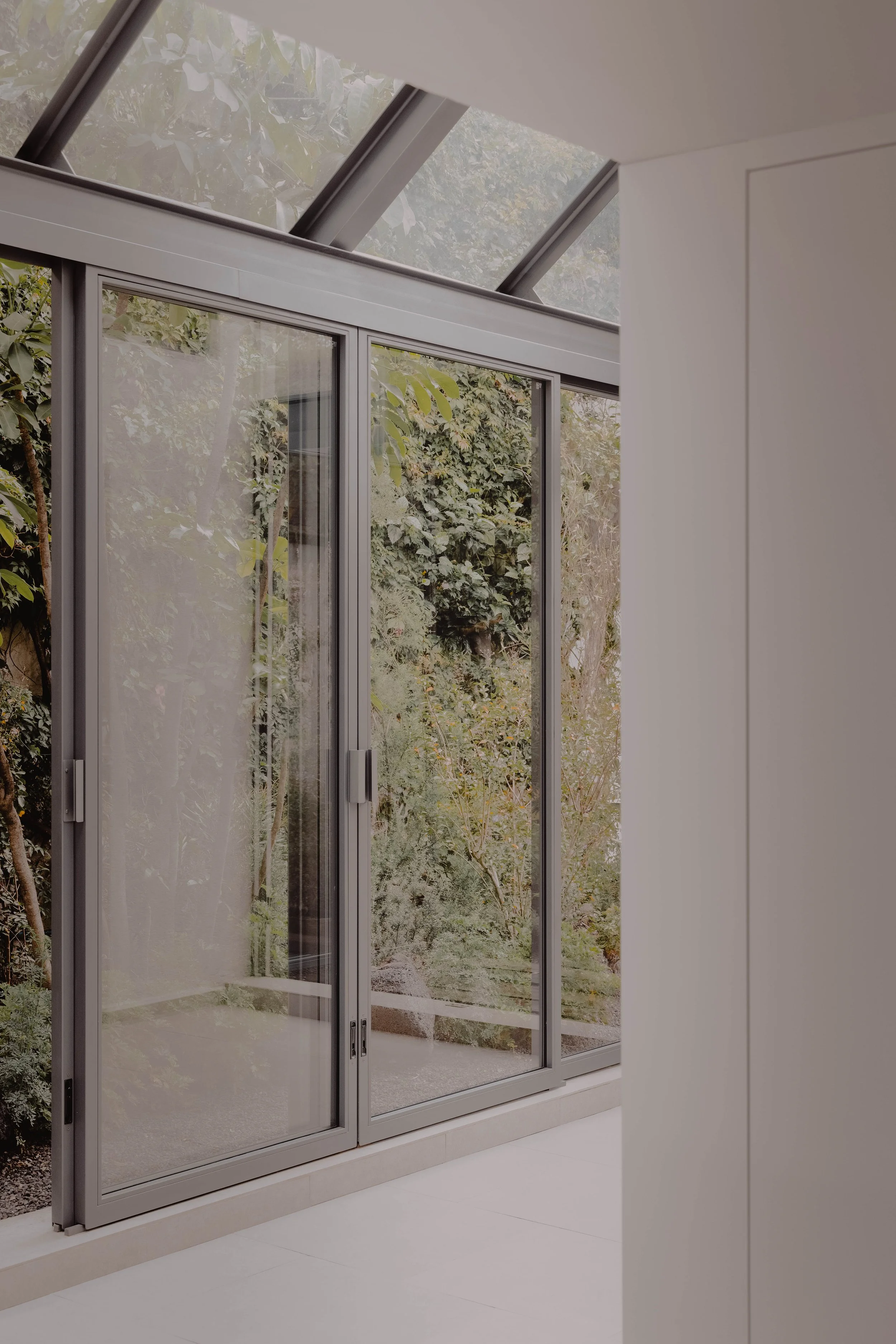 Veranda cristal herrería artesanal abraza jardín nativo Casa Escondida