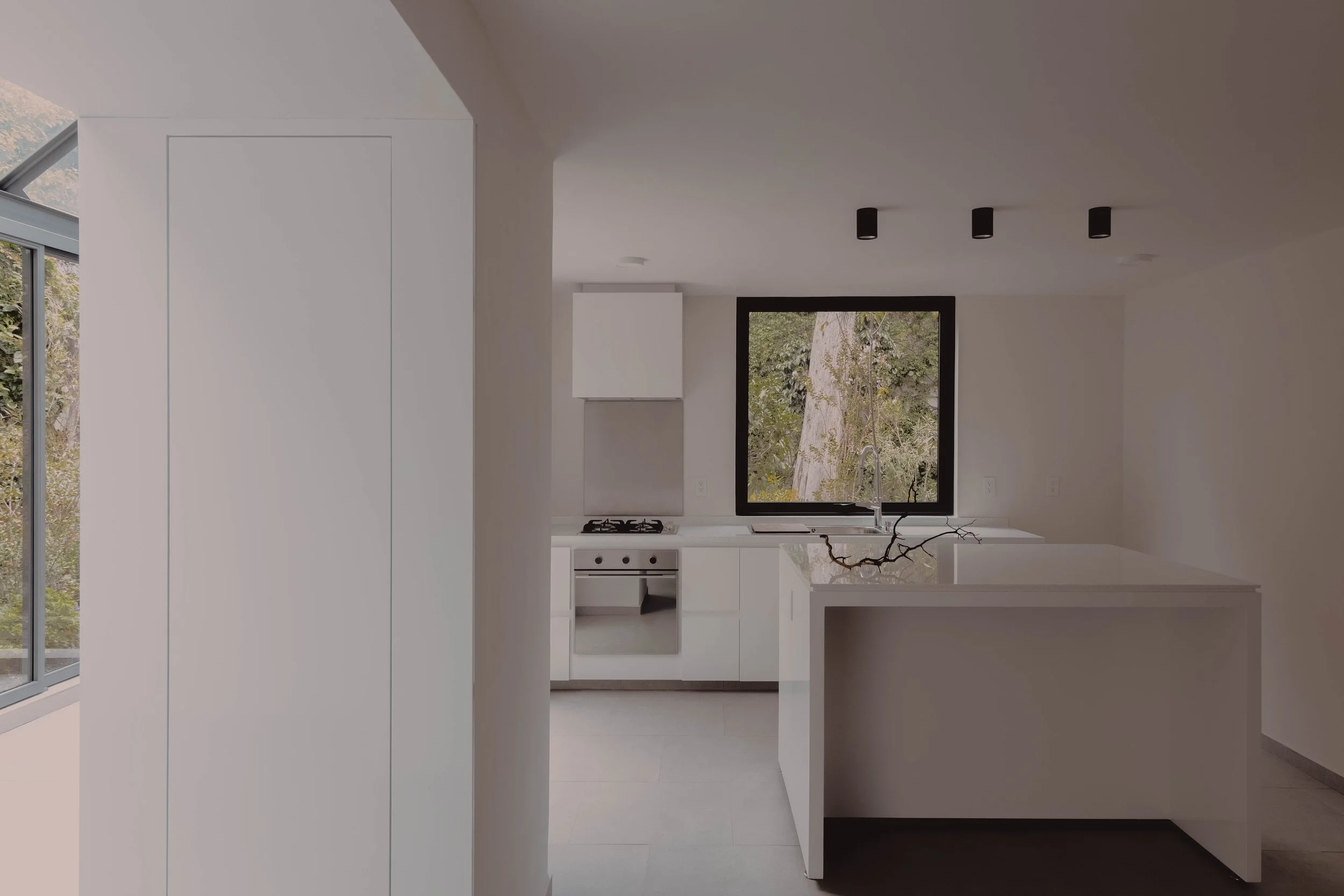 Cocina diseño minimalista, luz natural cambiante espacios transición veranda Casa Escondida