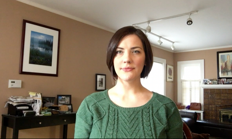 This is a still from my first one. As you can see the light on my face is okay, as I was in front of a window and had natural light, but the living room (and the messy desk) are a bit distracting.