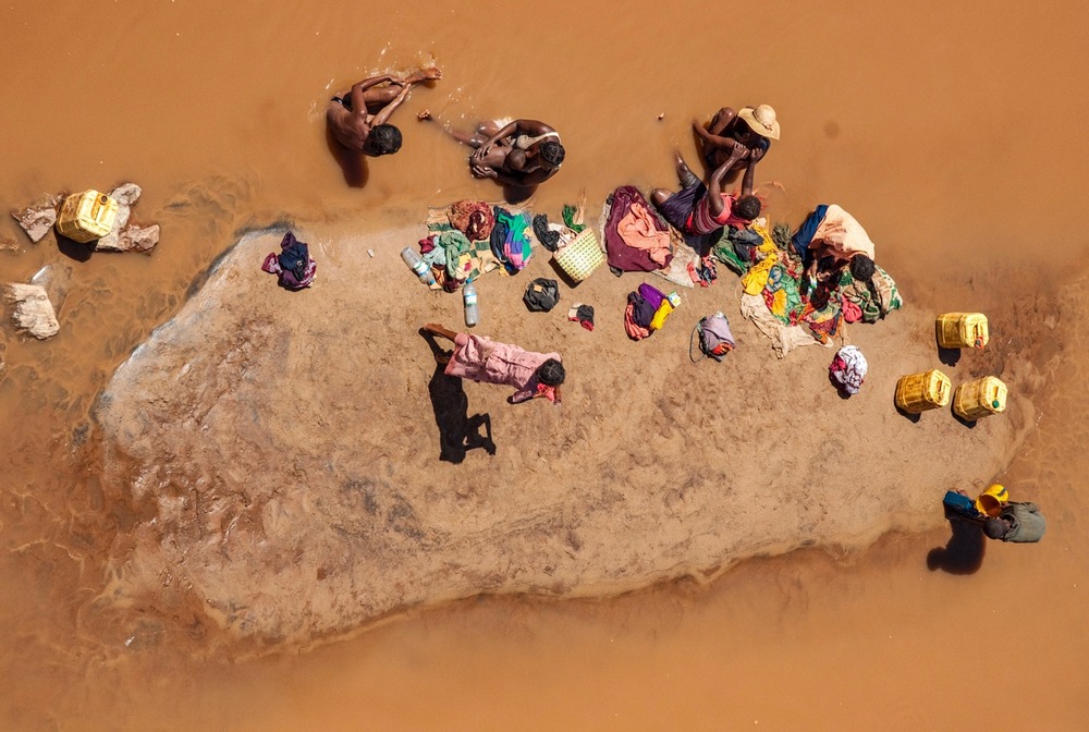 A FAMILY WASHES AND BATHES IN THE WATERS IN MADAGASCAR. PHOTO: CRISTINA MITTERMEIER
