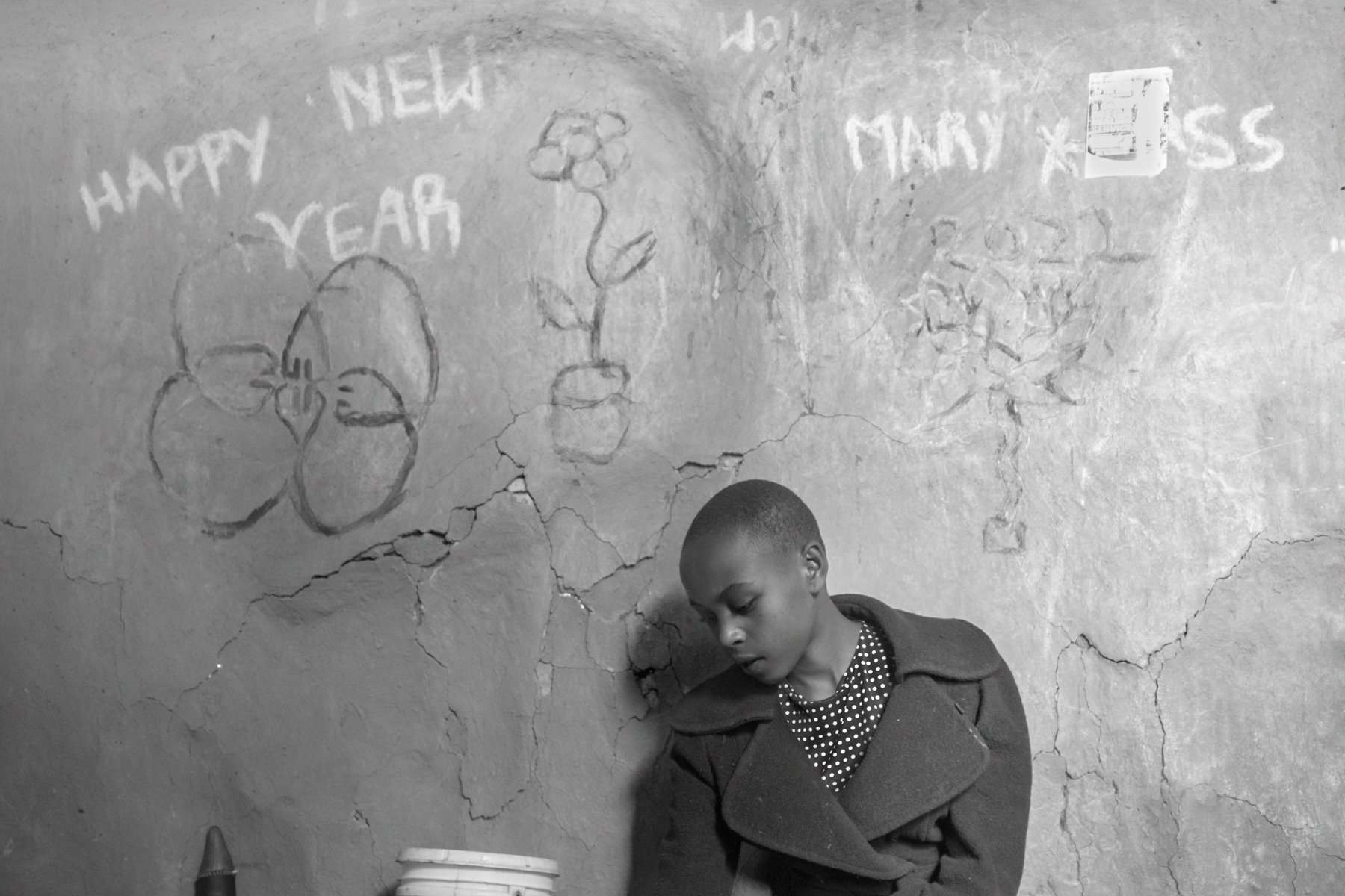  Maryamu Kisio, (12 years), rests against a wall in her family home that carries her drawings, Nadumoro, Laikipia county, Kenya. 