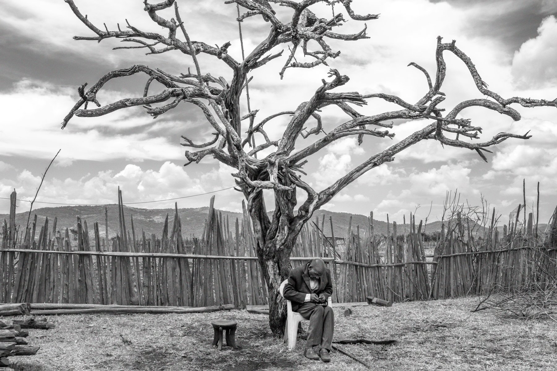  John Kisio, 82 years, sits under a tree in his homestead. “I have nowhere to go. If I die, I want to die on my land”. Nadumoro village, Laikipia county, Kenya. 