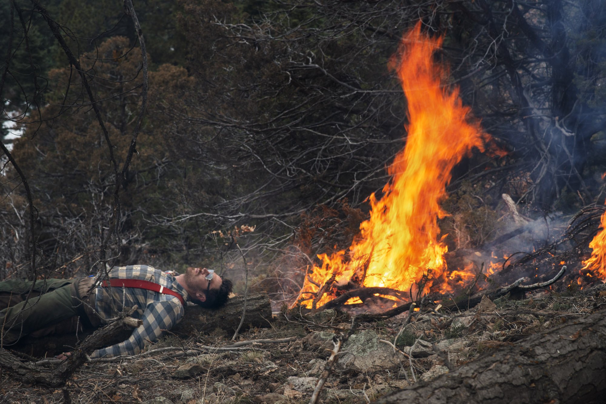   Hendrix Johnston, a local produce farmer and forester, rests by a controlled fire.  