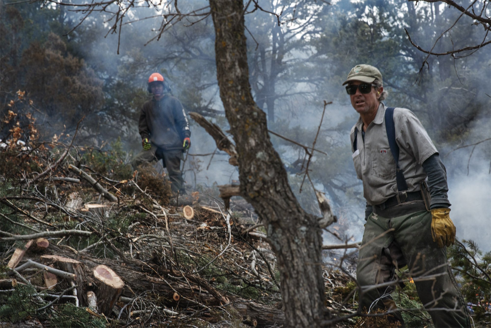   Mark Scheutz, forestry crew leader, and Smoke Romero survey their lop-and-scatter and controlled burn thinning efforts on the slopes of El Salto.  