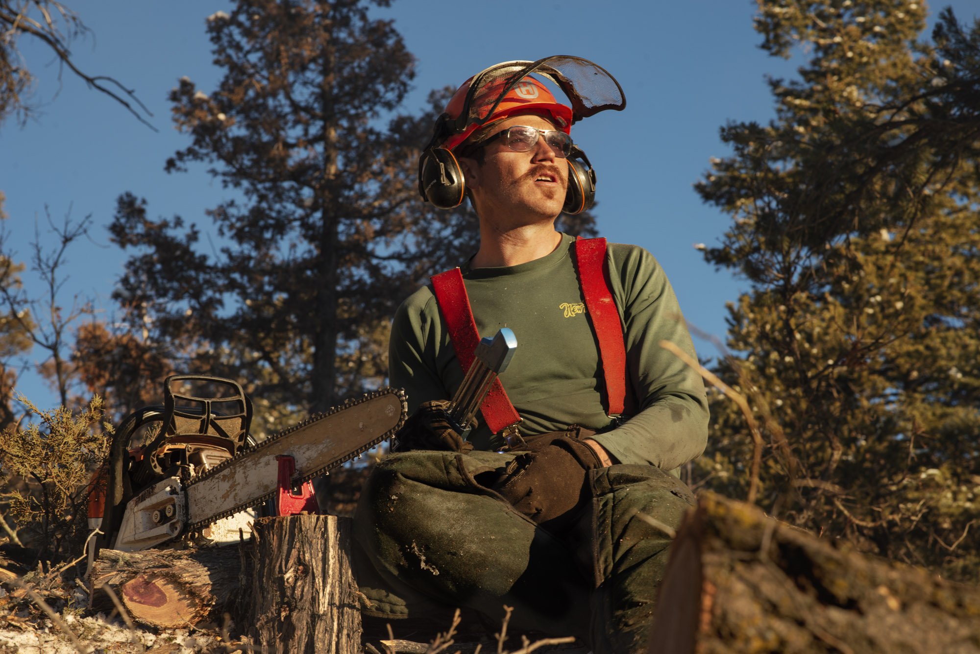   Hendrix Johnston takes a momentary break from sharpening his chainsaw to soak in the late day sunlight.  