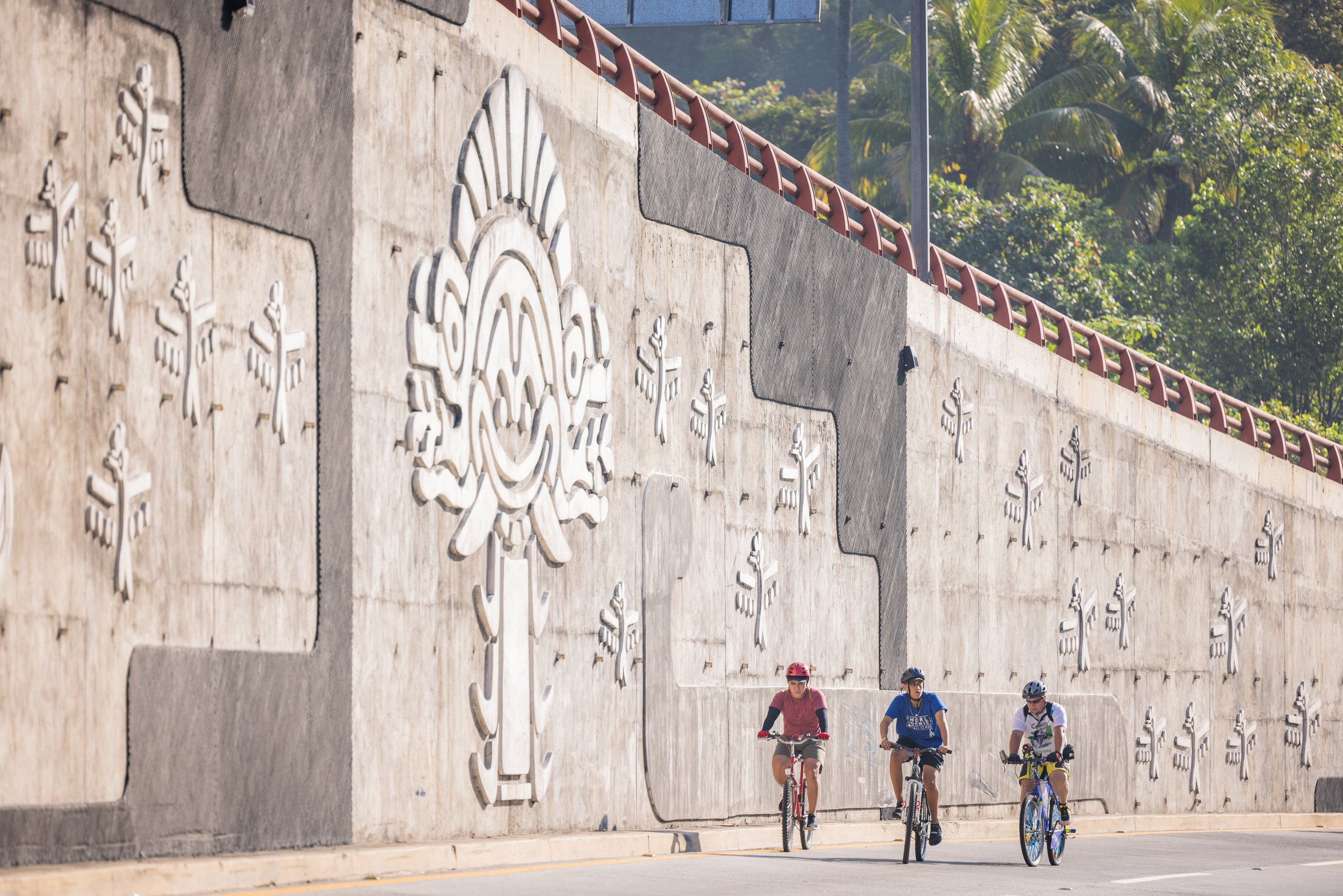  Three cyclists together on a group ride through San Salvador. 
