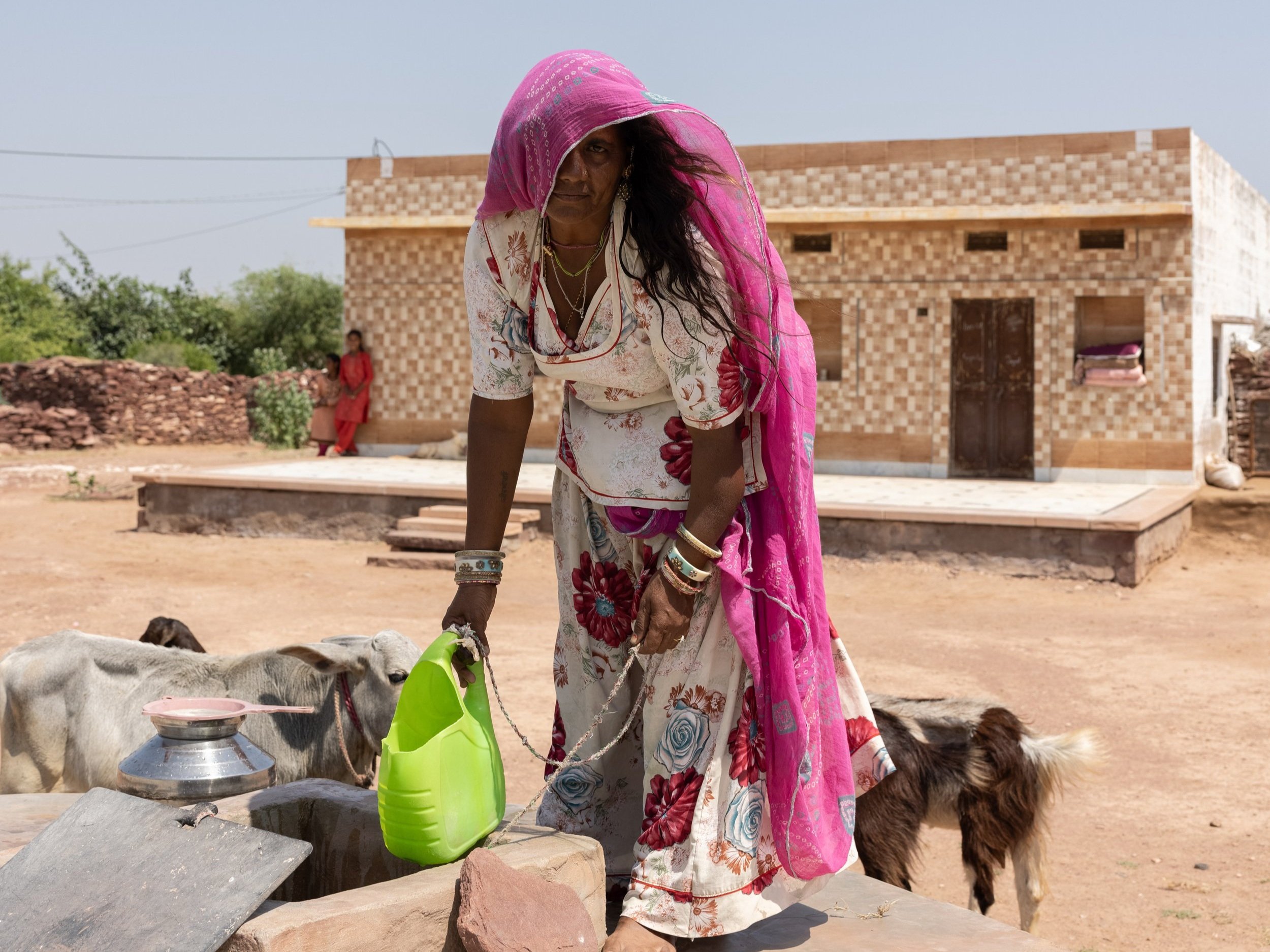 Jiwani Devi collects water from the rainwater harvesting tank outside her home in the Thar Desert.