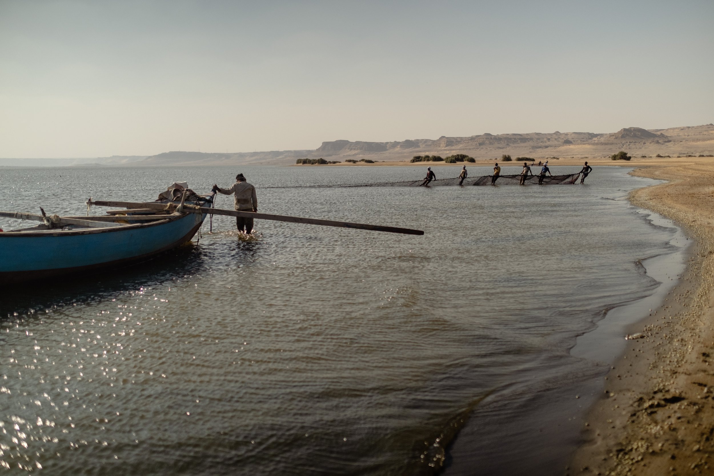 Local fisherman Anas pulls in his boat. Nearby, other fishermen pull their net to bring in fish that will be sold at the local market. September 09, 2022.