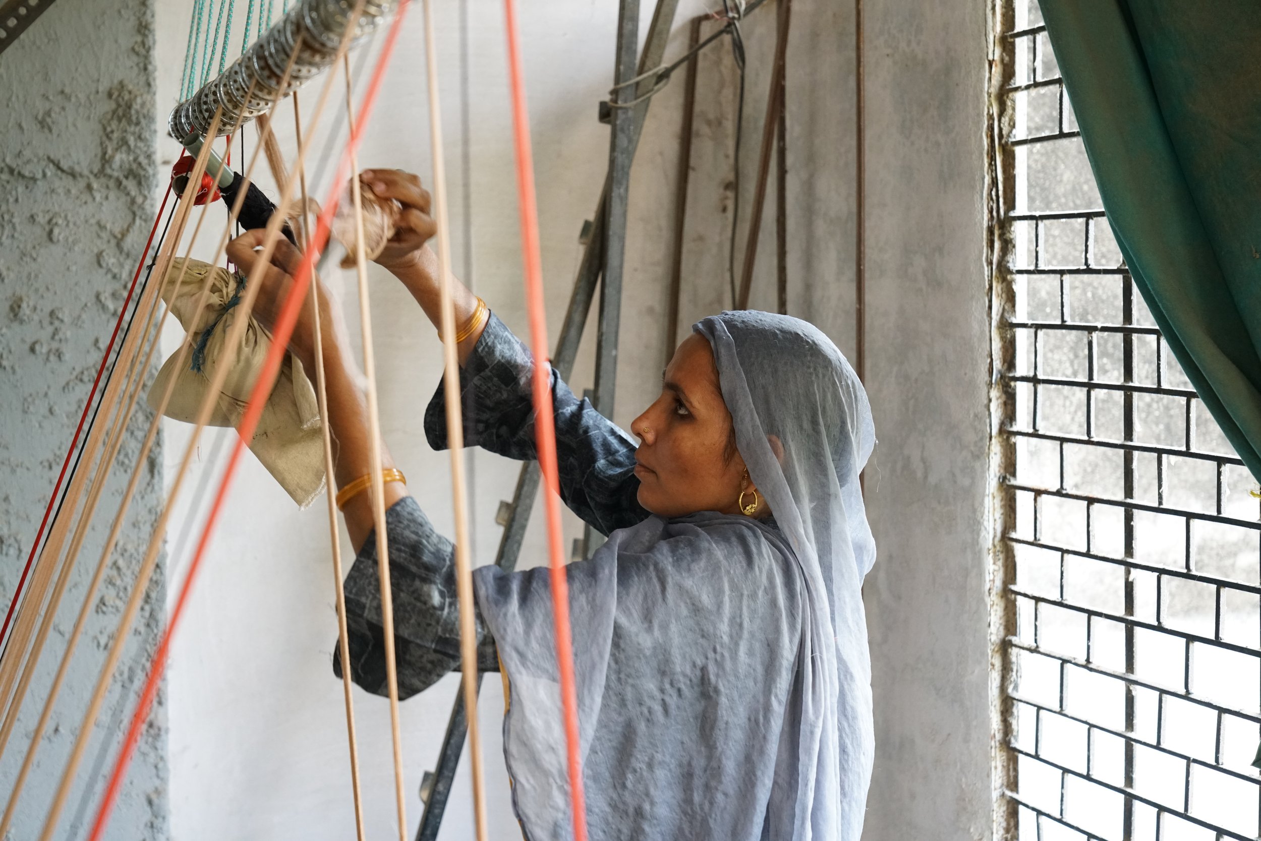 A woman engaged in the weaving process.