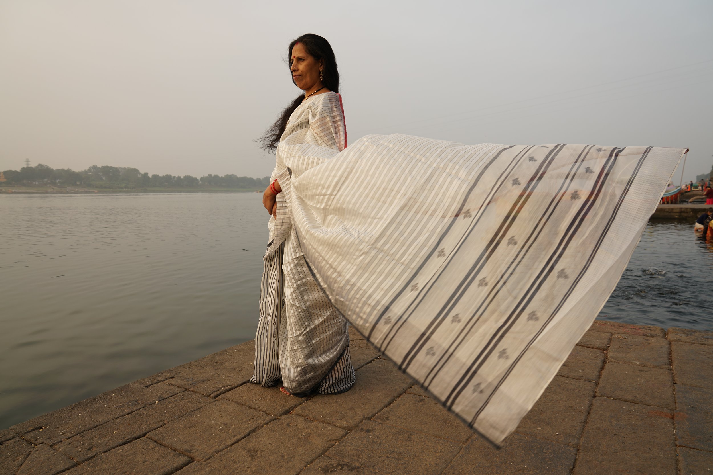 One of the weavers modelling the handmade fabric WomenWeave creates by the river.