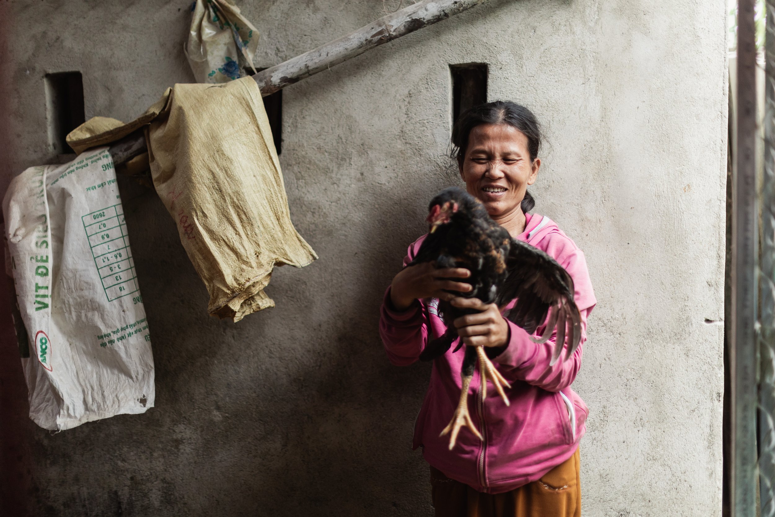 Ms. Dung smiles inside her chicken coop, which H4H volunteers built in 2022. The income generated from selling eggs and chickens has provided her with the means to improve her overall wellbeing.