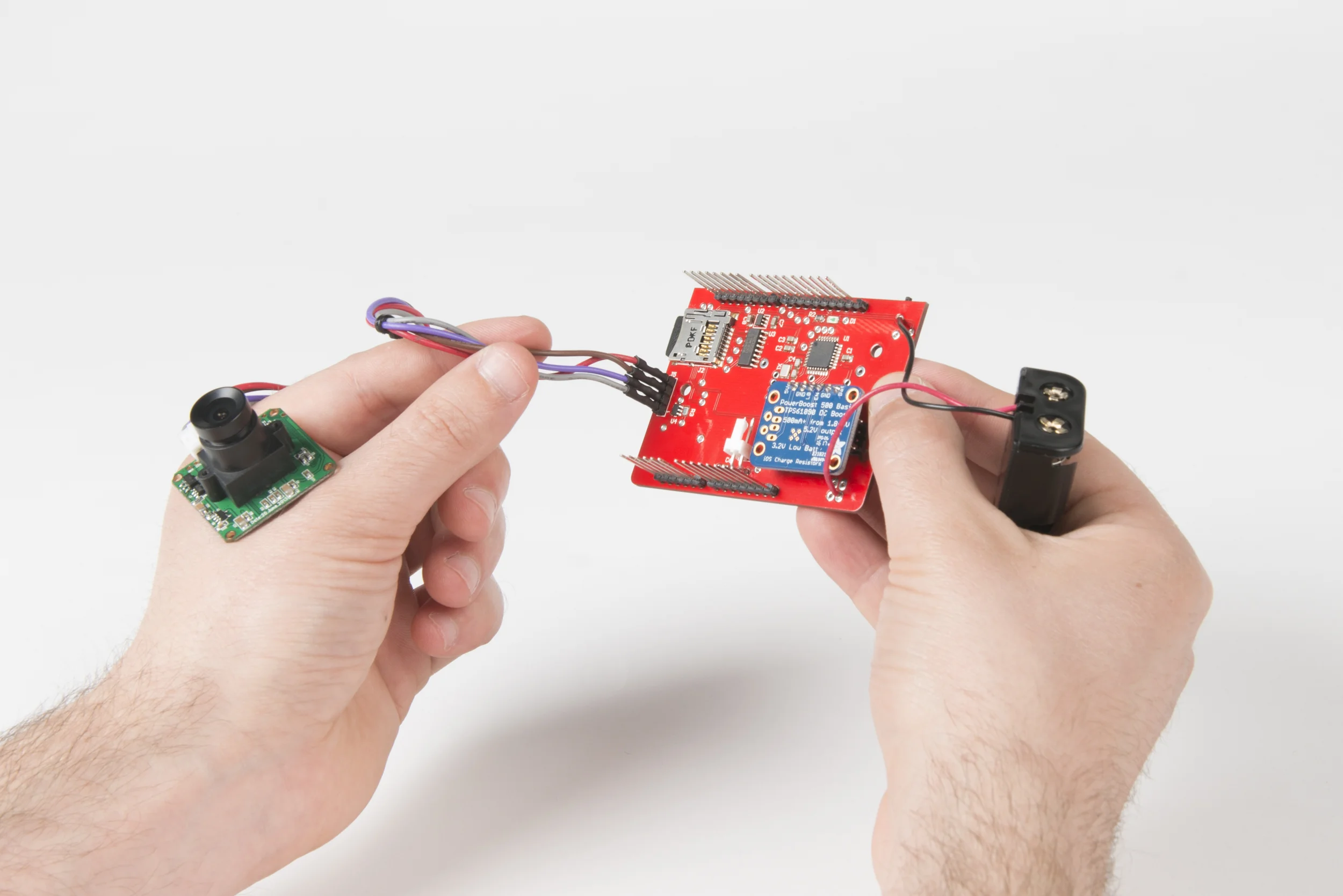Step 2 Connect camera module to shield. Make sure to match the order of the cables with the picture. Top to bottom: red, brown, purple, grey. Solder battery leads to the board observing the correct polarity.