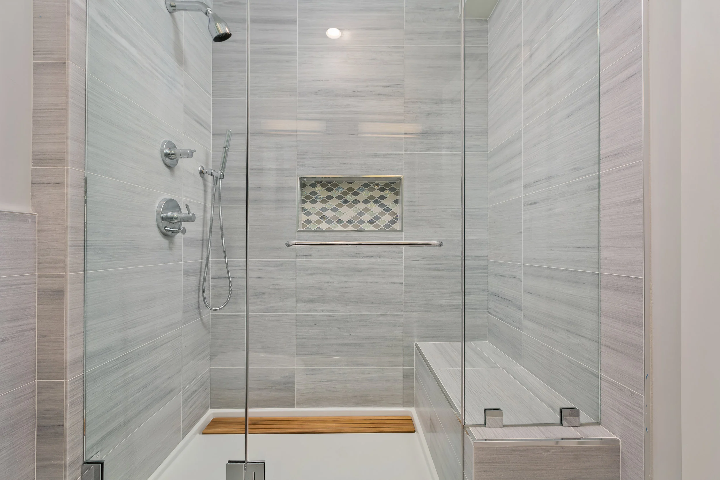 The Master bath features a custom glass shower and marble tile