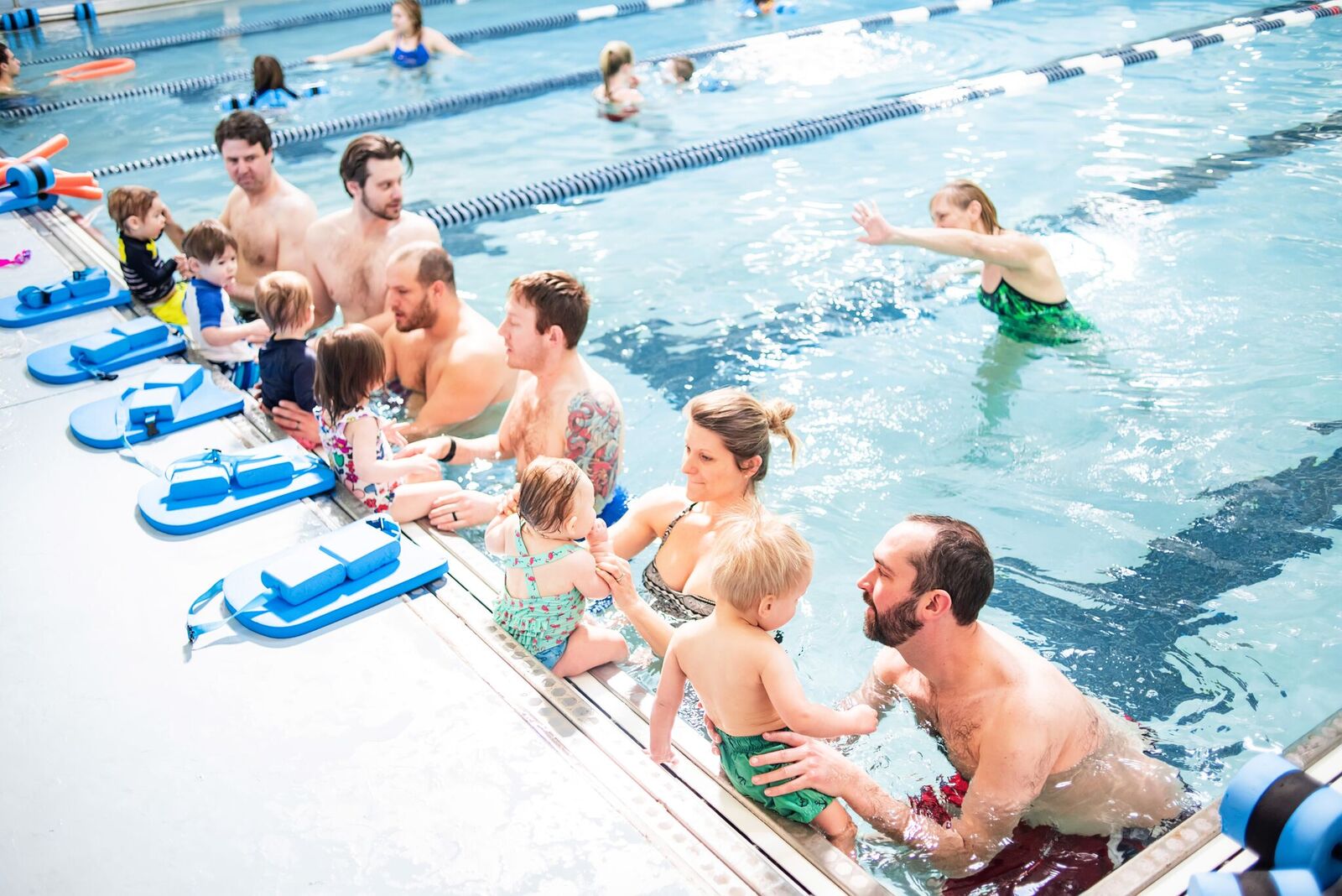 Child swimming in pool with parents