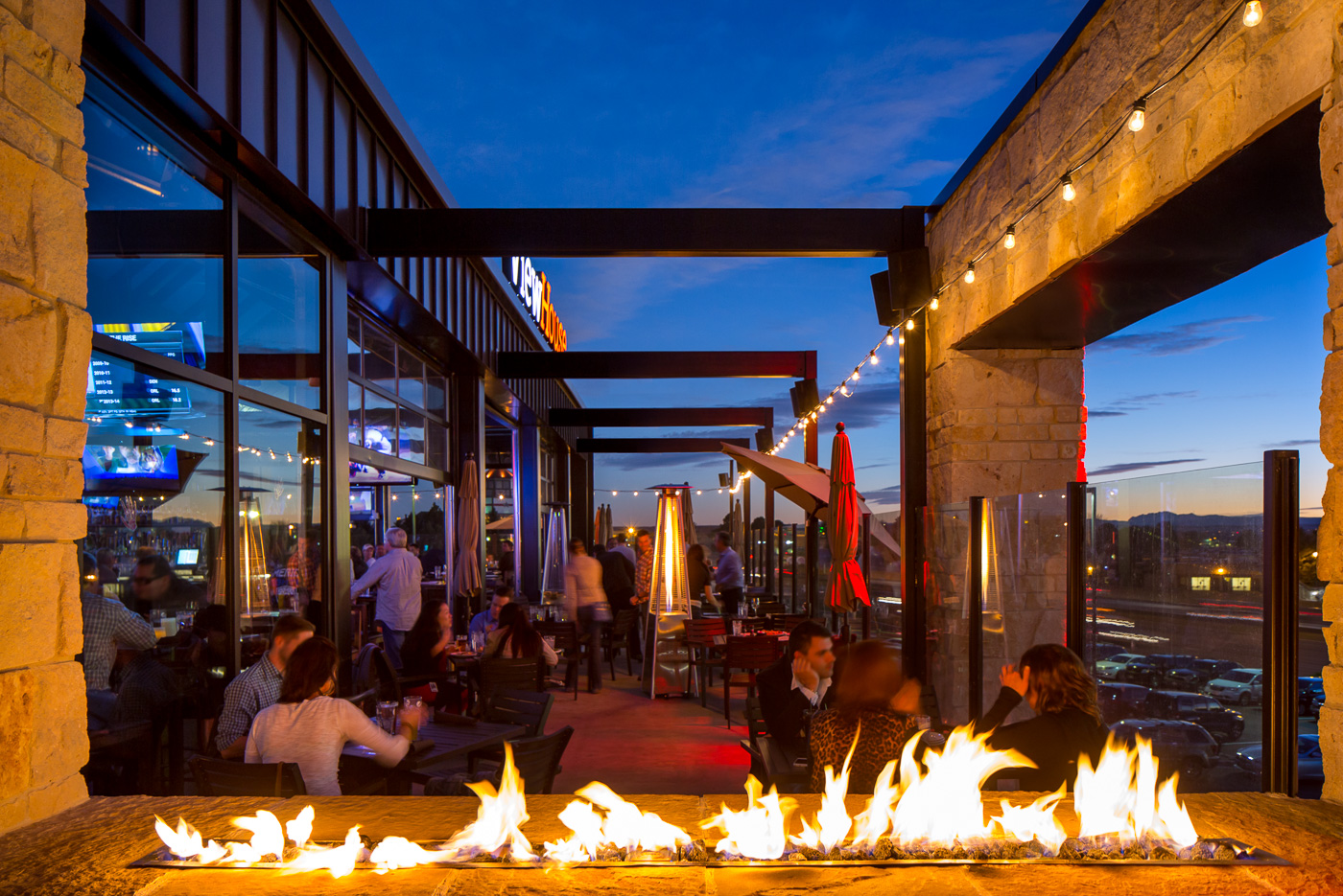At night, a portion of the upstairs space transforms into a late night lounge with an elevated DJ booth, private deck, and cozy fi replace.
