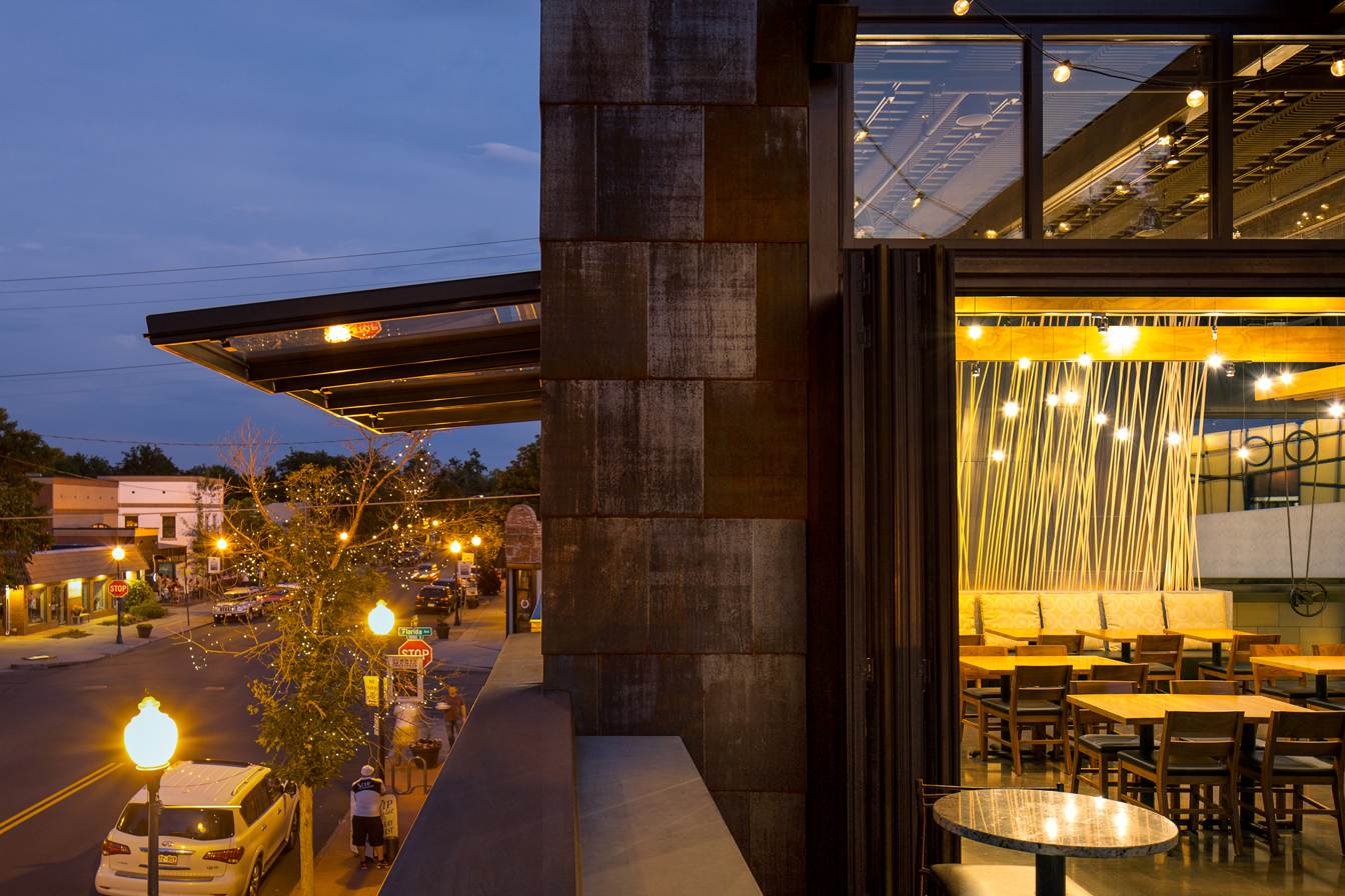 10’ tall walls of glass slide and hinge open while a 60 ‘ long skylight rolls open to kinetically change the experience into alfresco dining, engaging diners with the active street scene.