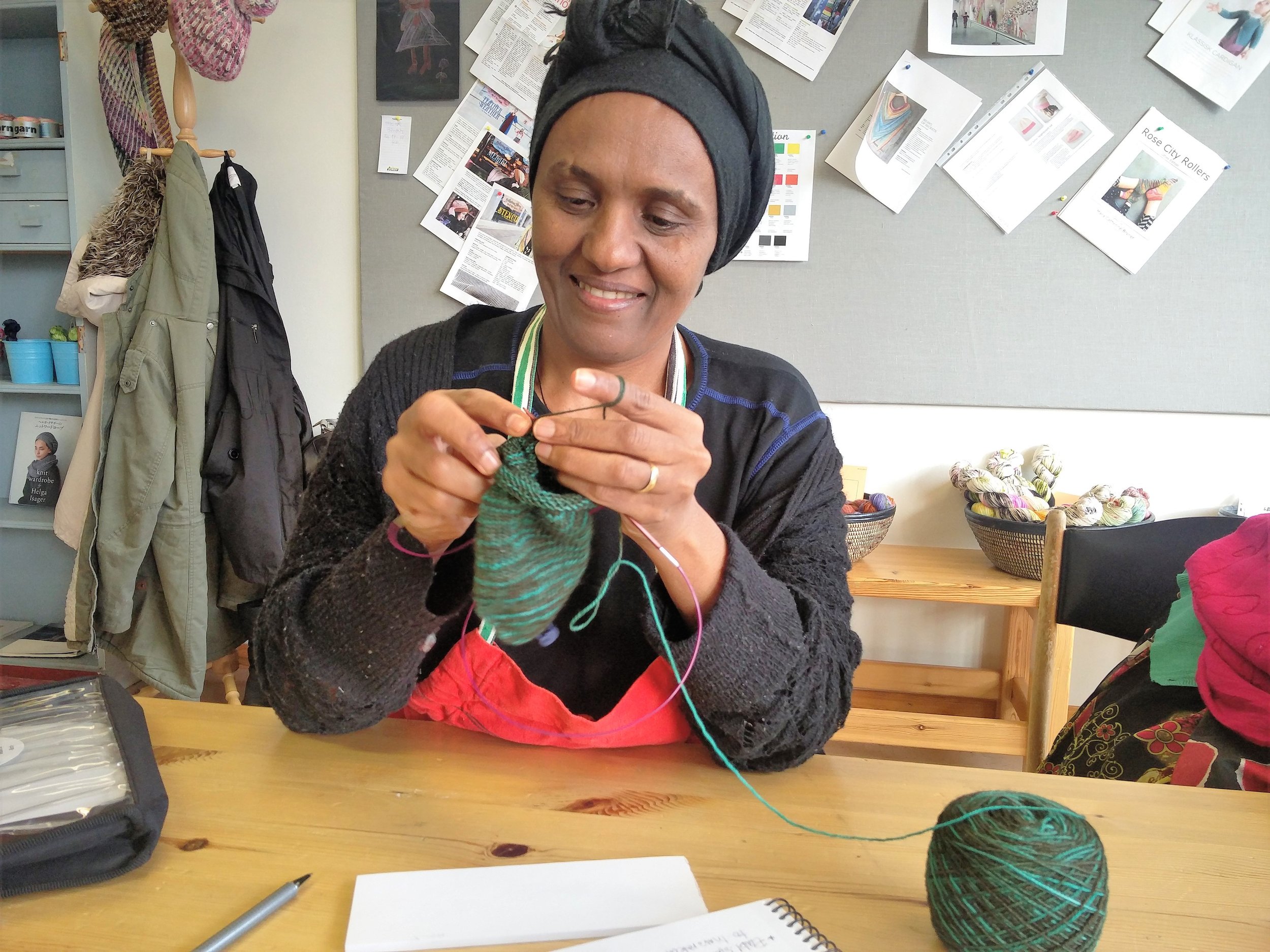 I morgen begynner Akberet fra Eritrea, og det gleder vi oss helt vilt til! Hun kan, som dere ser, allerede strikke. Her låner hun Halimos strikketøy, sokk nummer to, og skjønte teknikken med magic loop med en gang:-) Hun kan også sy, så nå lurer vi litt på om vi skal finne på noe vi kan sy og selge i tillegg.