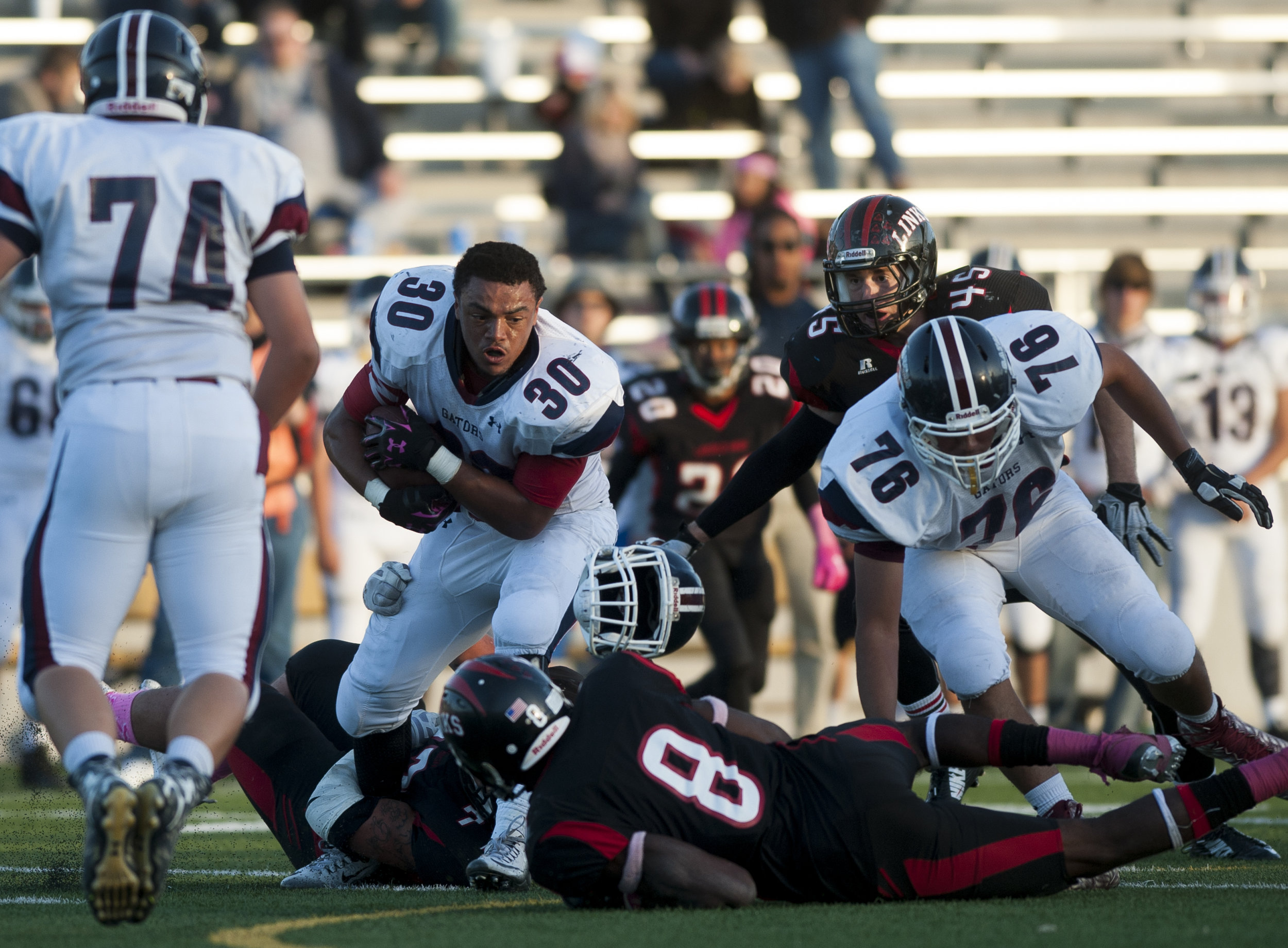  Lincoln North Star's Tavlin Hunt (30) stays upright after having his helmet ripped off in the third quarter of action at Seacrest Field Oct. 16, 2015 in Lincoln, Nebraska. 