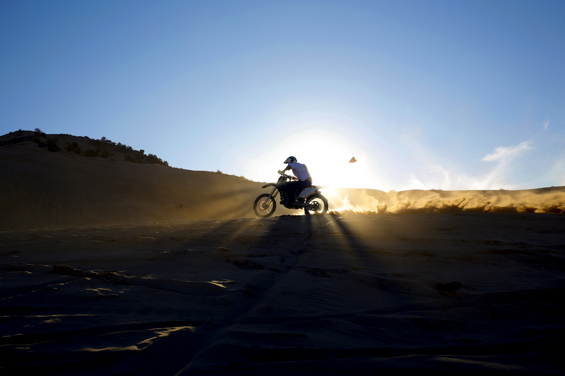  As the last light of the day fades away a dirt bike rider speeds up a dune ridge at Little Sahara Recreation Area February, 28, 2016 in Jericho, Utah.  