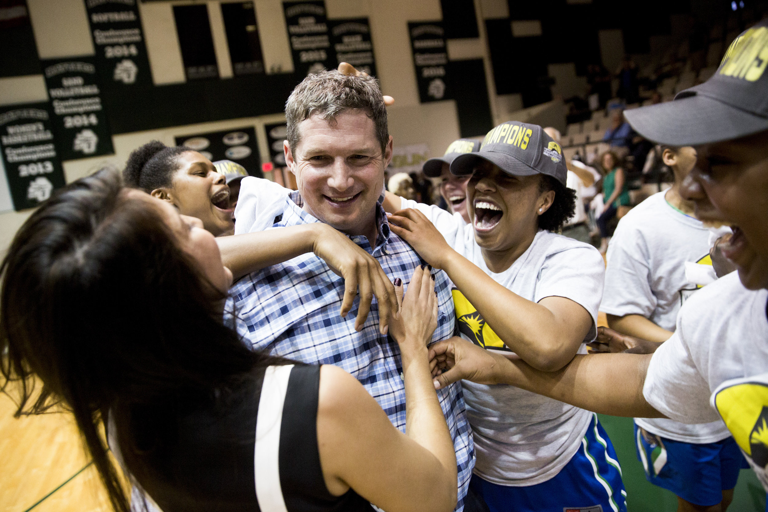  The FGCU women's team swarms head coach Karl Smesko after defeating Stetson 77-70 in the Atlantic Sun Championship game at the Edmunds Center Sunday, March 12, 2017 in DeLand, Fla. 