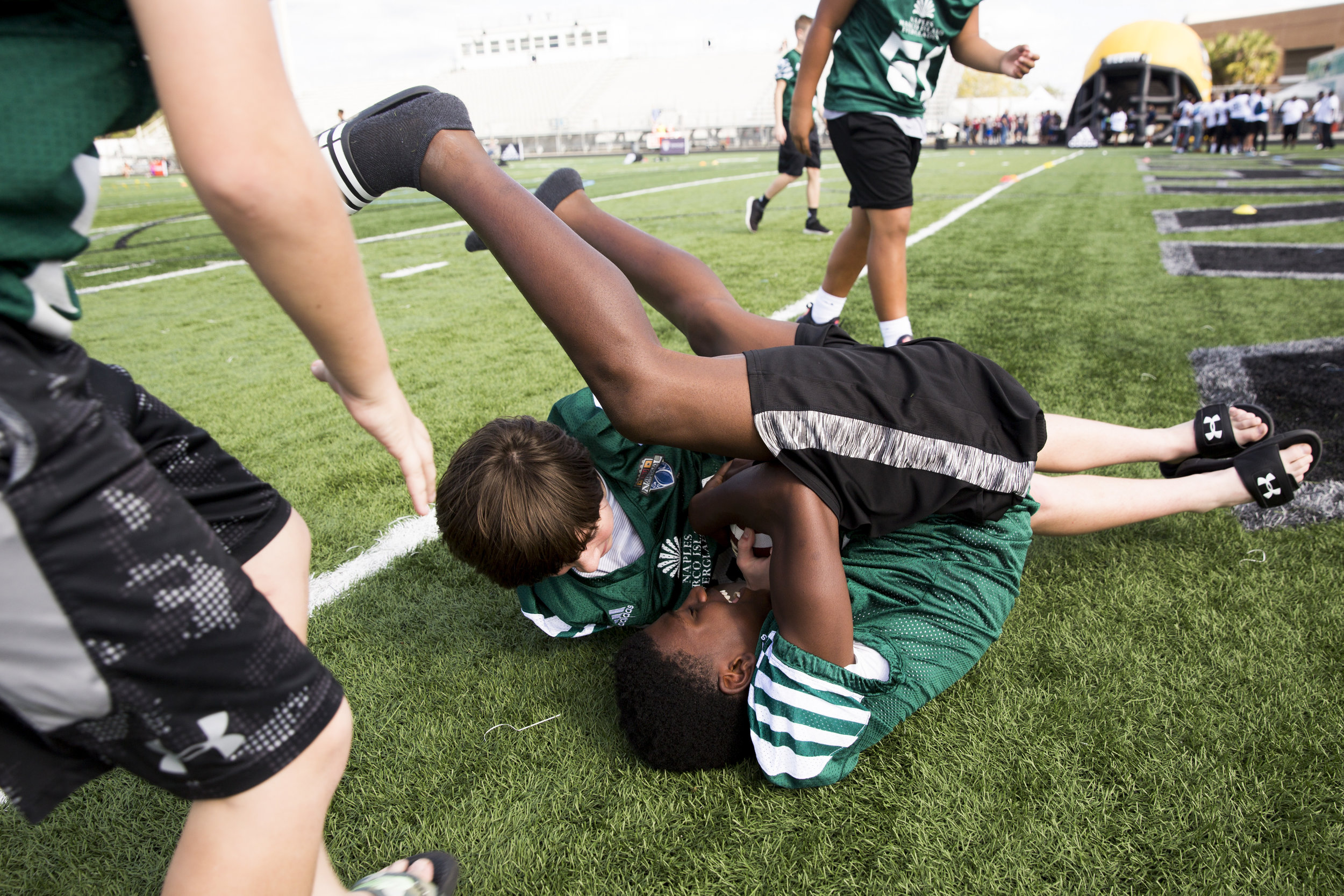  James Johnson, 12, does a somersault while wrestling for the ball with Dane Aaberg, 12, both with the 6th Grade team from Dallas, Texas as middle-school football players from across the country showed up for registration and a pep rally to kick off 