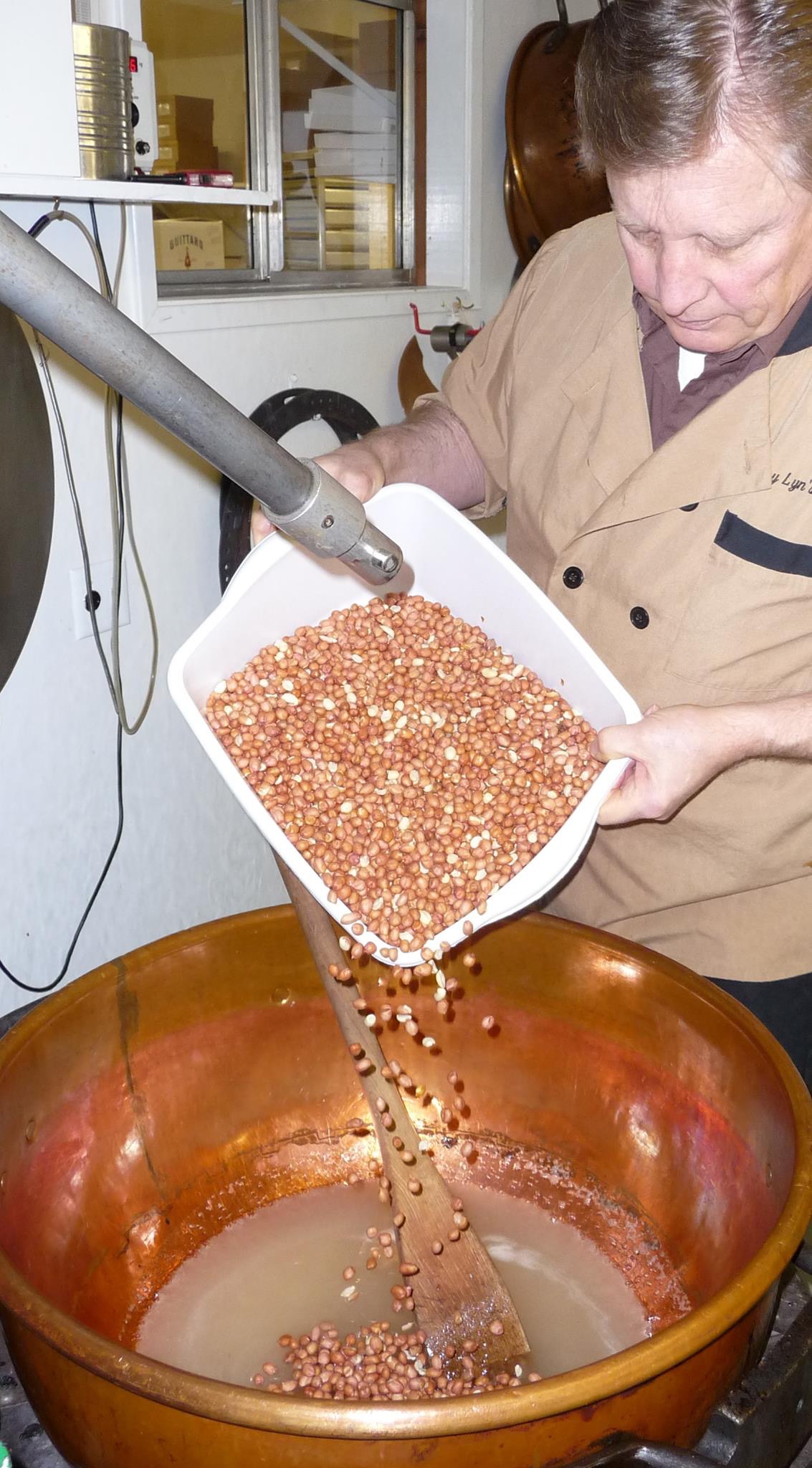 Adding the peanuts to the copper kettle for the Peanut Brittle.