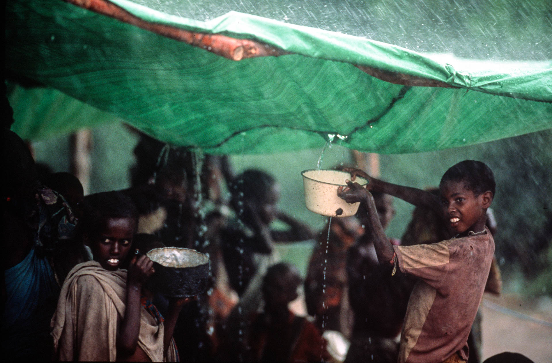  Bardera, Somalia - December 1992 
In Bardera the rain is an opportunity to have a bath and drink some fresh water. 