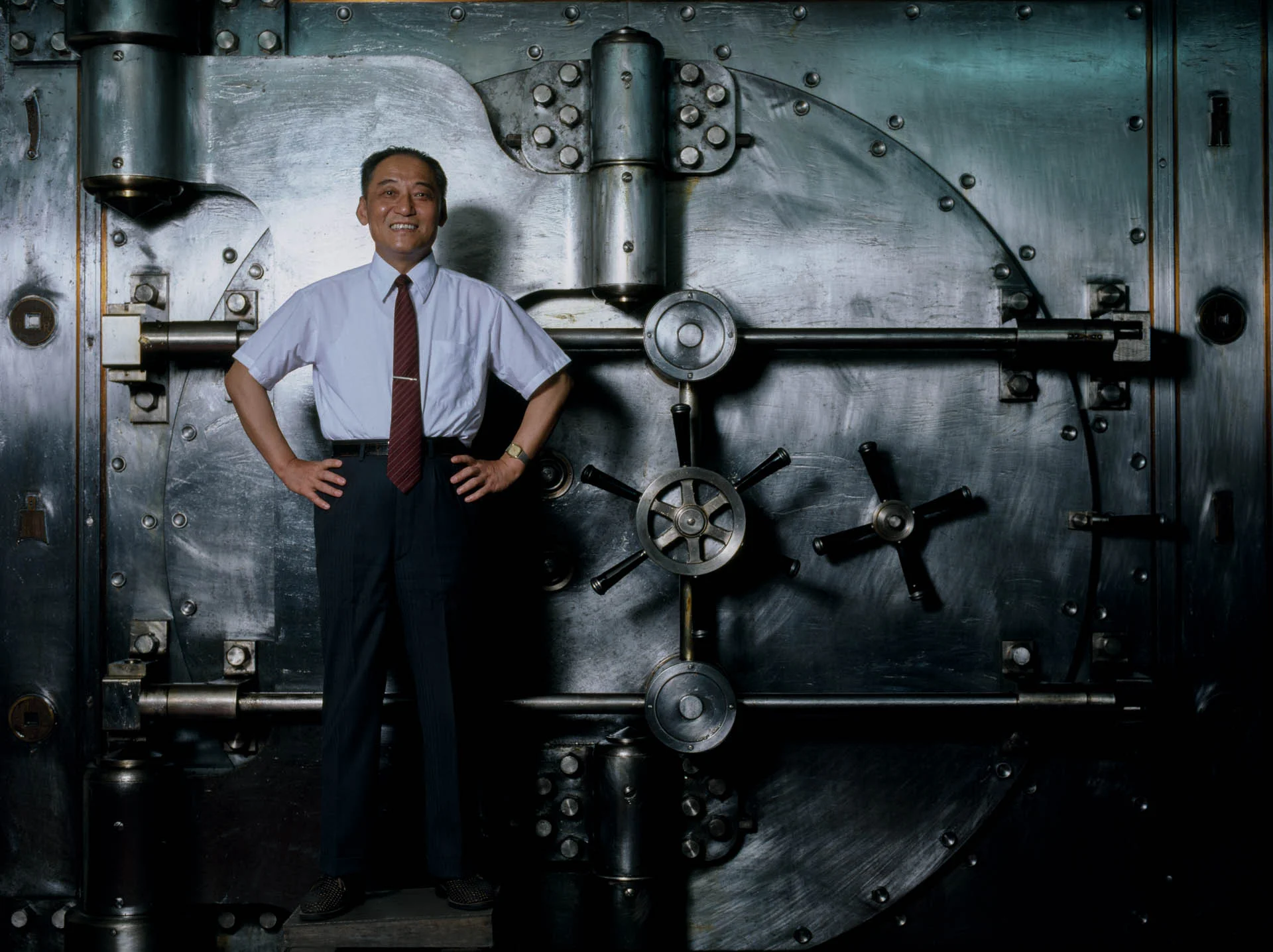 Shanghai, China - June 1988 General Director of the Bank of China Xue Jingcheng stands guard near the door of a safe holding 10 billion dollars. 