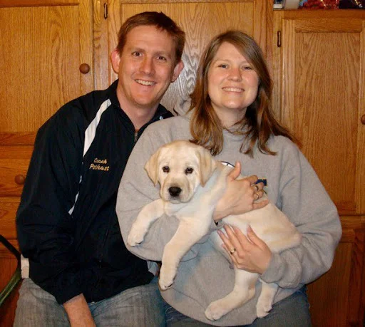 Mike with his wife Sarah and Rufus as a puppy.