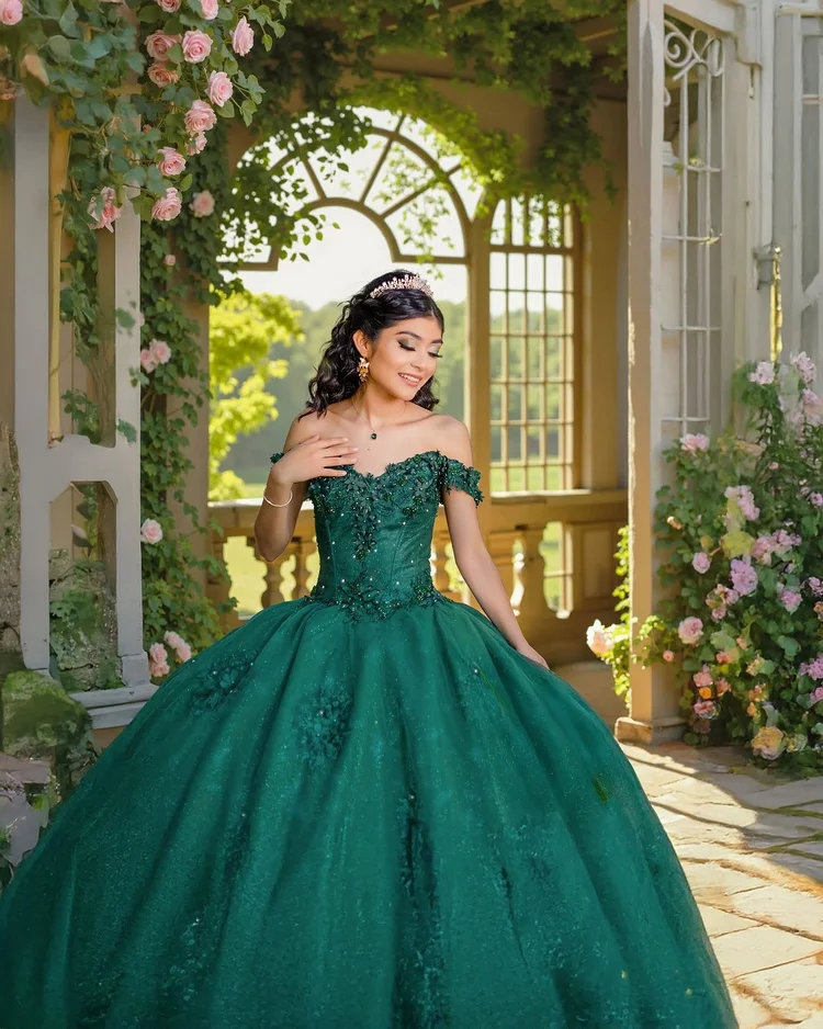 Quinceañera portrait in an emerald gown beside a rose arbor, by Henry M Production