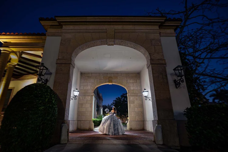 Quinceañera portrait framed by a stone archway at night, by Henry M Production