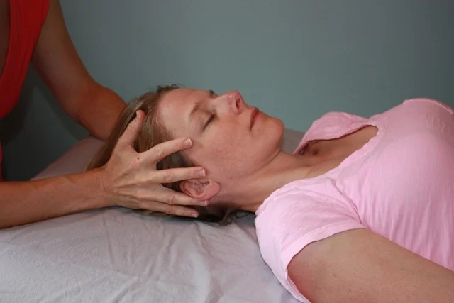 Above, I'm using a "vault" hold on the client. This hold originated with Dr. Sutherland, an Osteopath who gave rise to craniosacral therapy through his cranial concept within Osteopathy. It is a hold that allows the therapist to contact at once all the bones in the skull while staying present to the body as a biodynamic whole. It is an excellent hold to access the membranous system, including the dural membranes of the skull and spinal chord, and the brainstem which can be affected by blows to the head. Top Photo: Thoracic Inlet Hold, a great contact especially for calming a "charged" sympathetic nervous system, the division of the autonomic nervous system that provides our "fight or flight" response. It is also an effective hold to be present to the vast amount of anatomical structures running through the region of the neck.