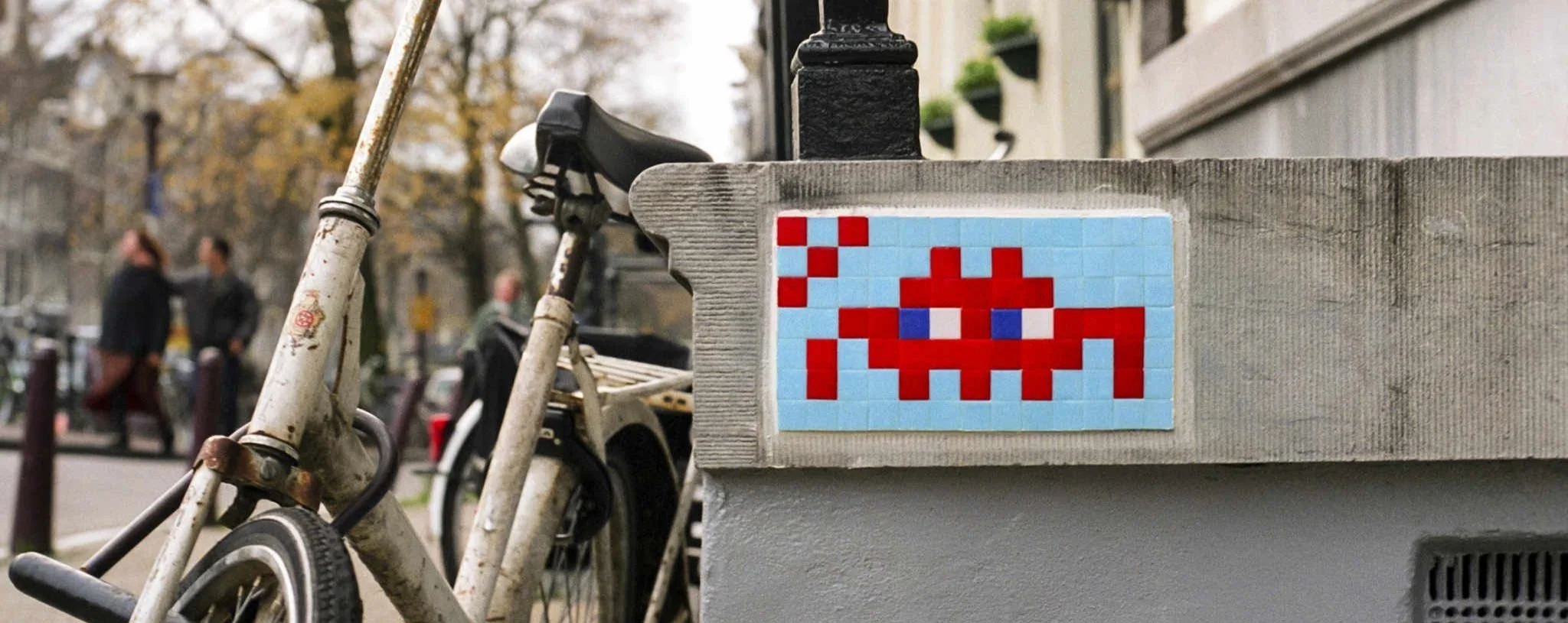 Invader pixel mosaic installed on a street wall