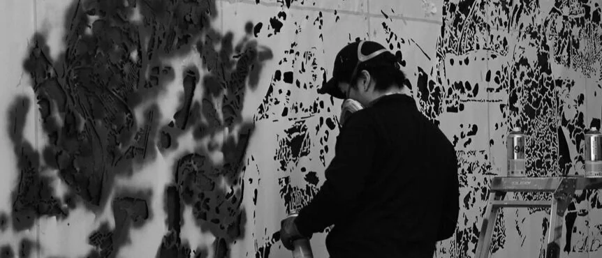 Japanese artist RoamCouch working on a large-scale stencil artwork
