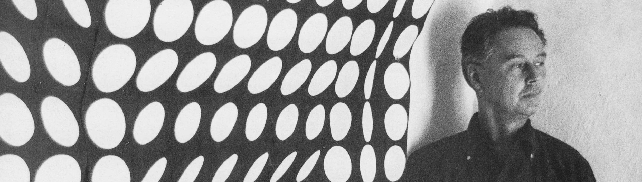 Victor Vasarely in front of one of his geometric Op Art compositions