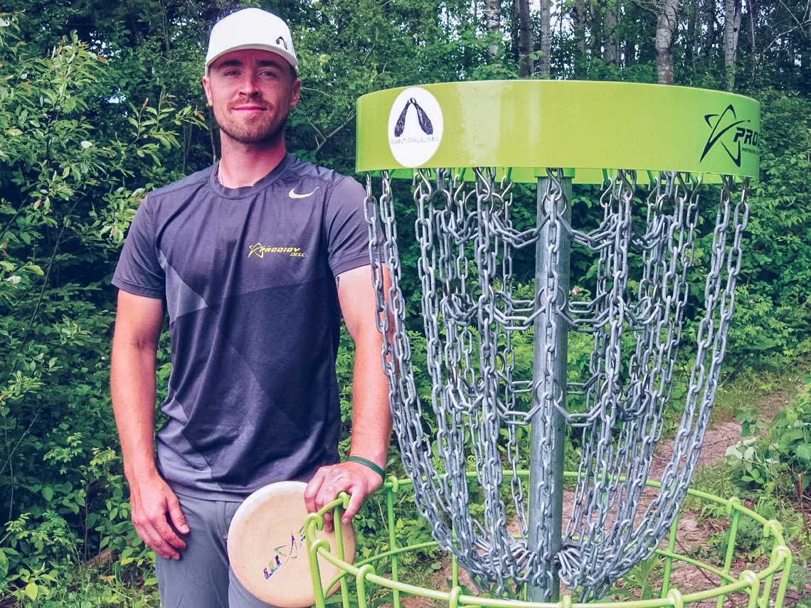 Scott GerdesCale Leiviska stand next to one of the state-of-the-art disc golf baskets one the Painted Turtle course he designed for the City of Mountain Iron at the West Two Rivers Reservoir campground.