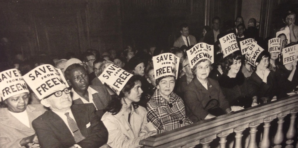 Citizens crowd into City Hall wearing signs on their heads to express their opposition to the freeways being erected all over San Francisco. Source: San Francisco History Center, San Francisco Public Library.