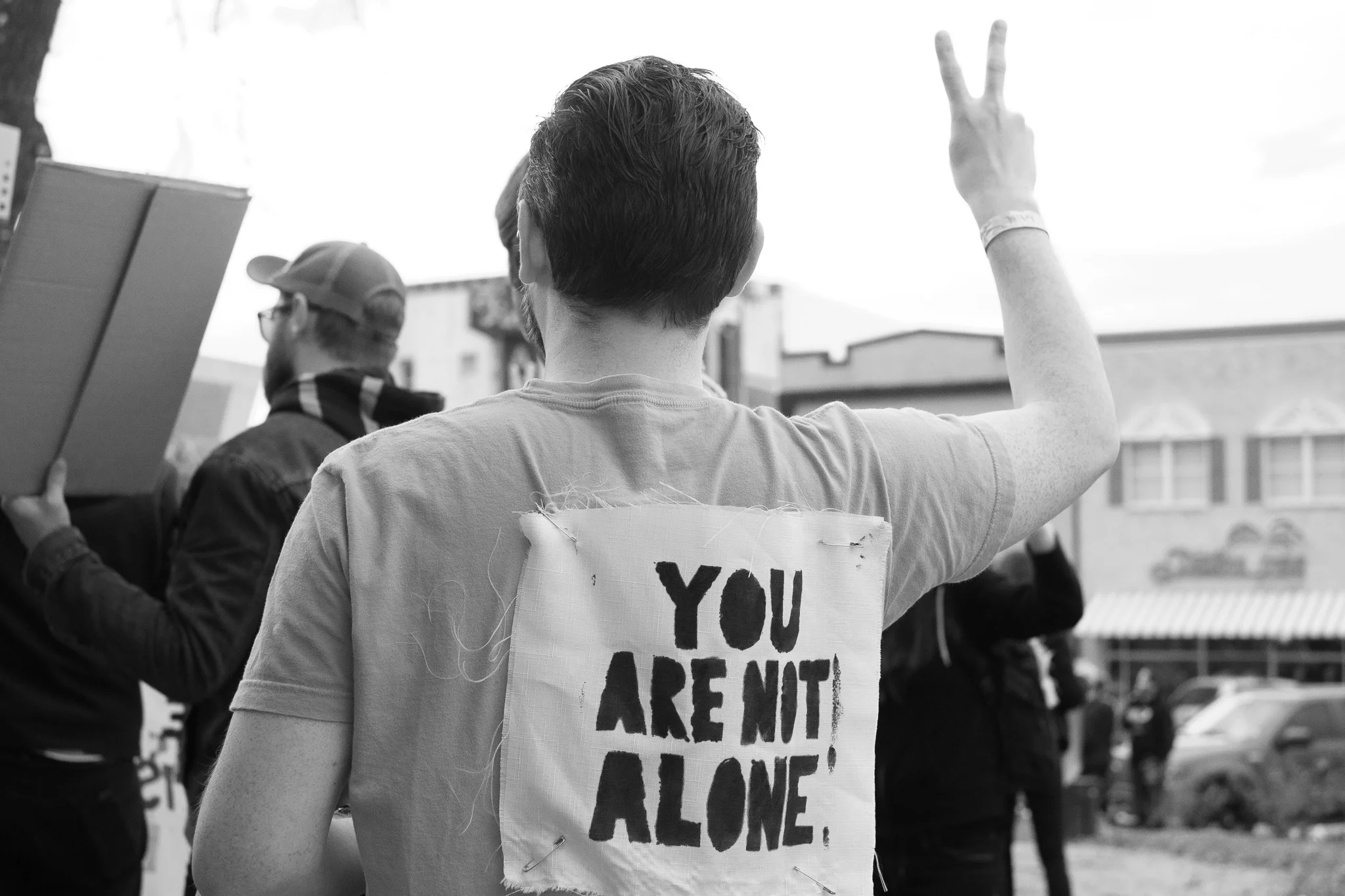 A rally participant holds up the peace sign during a period of silence at the Denton Women’s March, January 21st, 2017