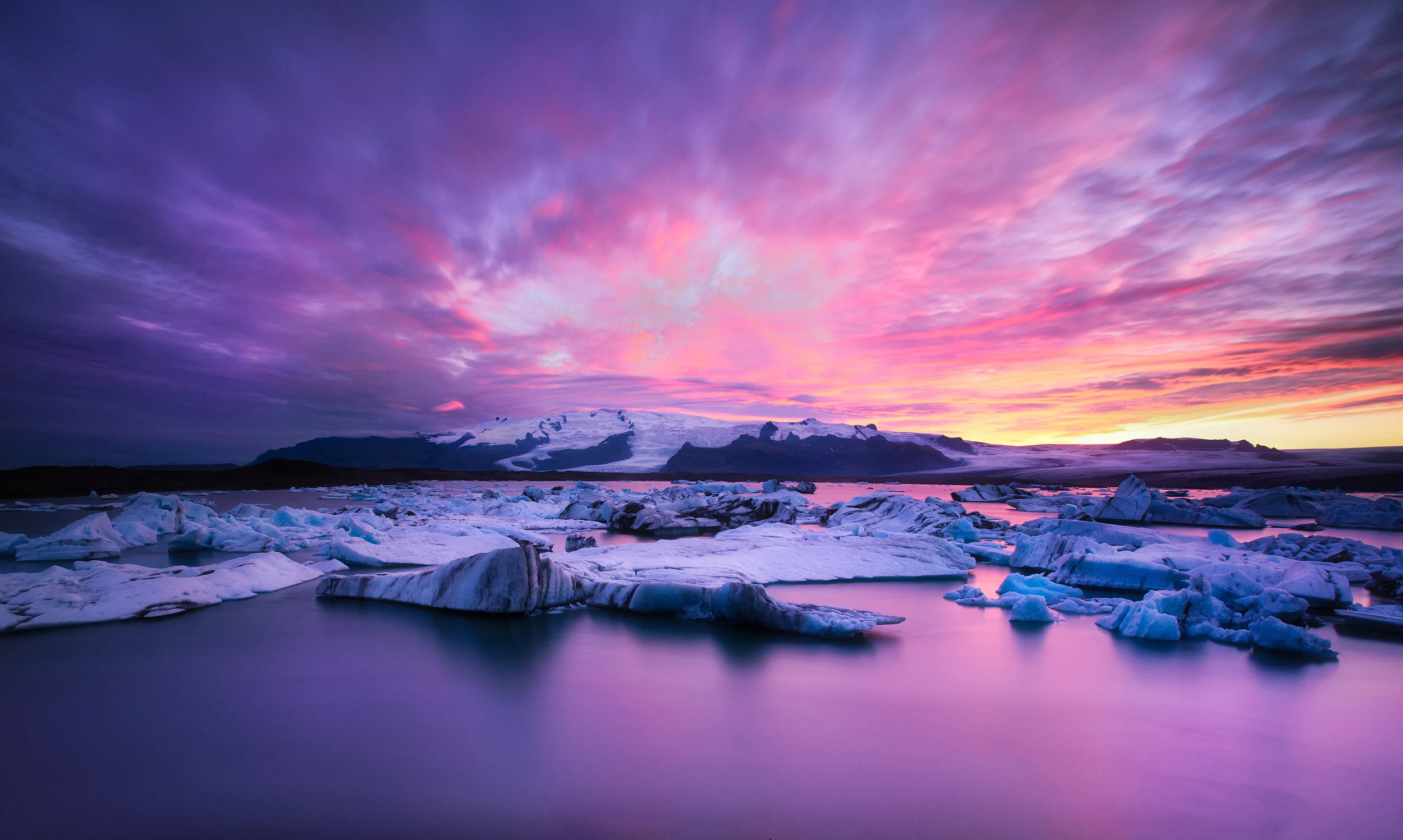Jokulsarlon Sunset at the lagoon of Jokulsarlon. The huge Vatnajökull glacier (the biggest icecap outside of the two poles) is in the background and a branch of it comes down the valley to the lagoon where icebergs calve off, float across the lagoon, and then eventually out to sea. The ice here is 1000 years old apparently
