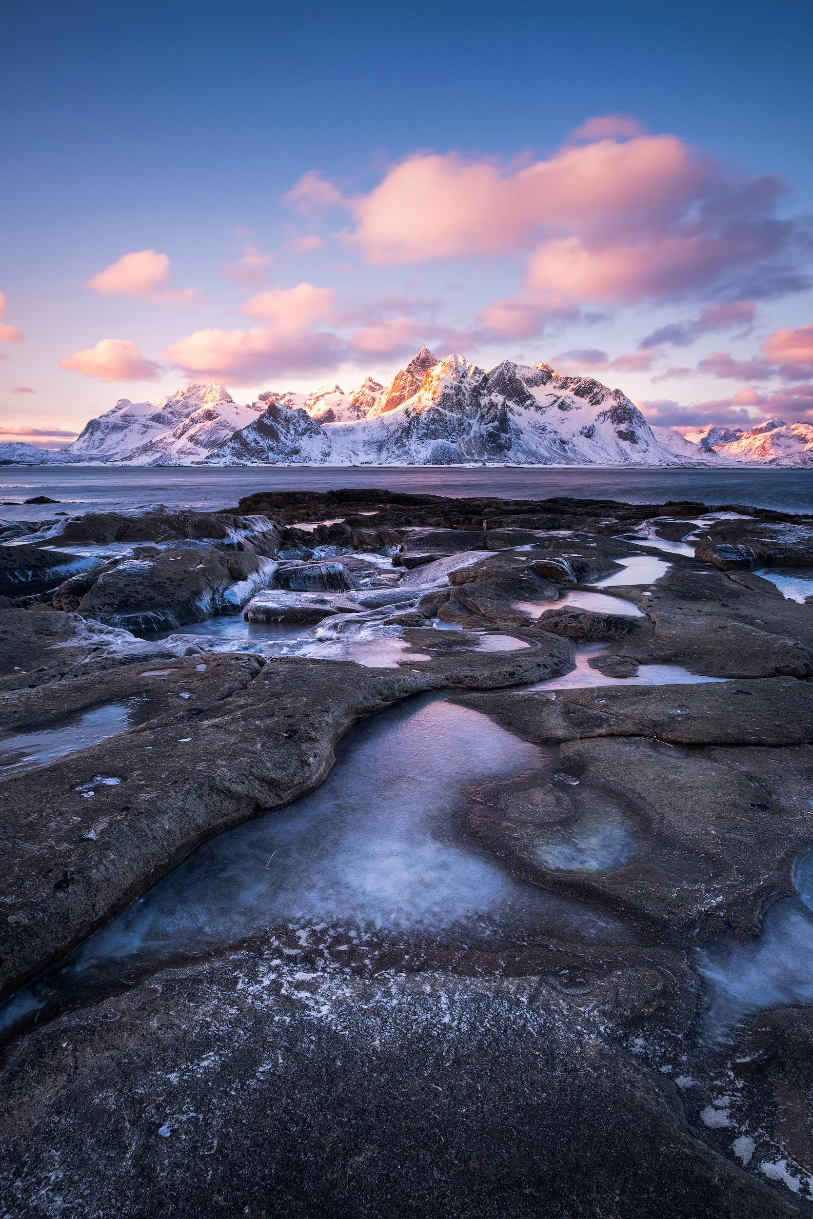 Sunrise in Vareid The sun's first light paints the snow covered peaks of Lofoten in winter. I shot this from the ice covered rocks of Vareid.