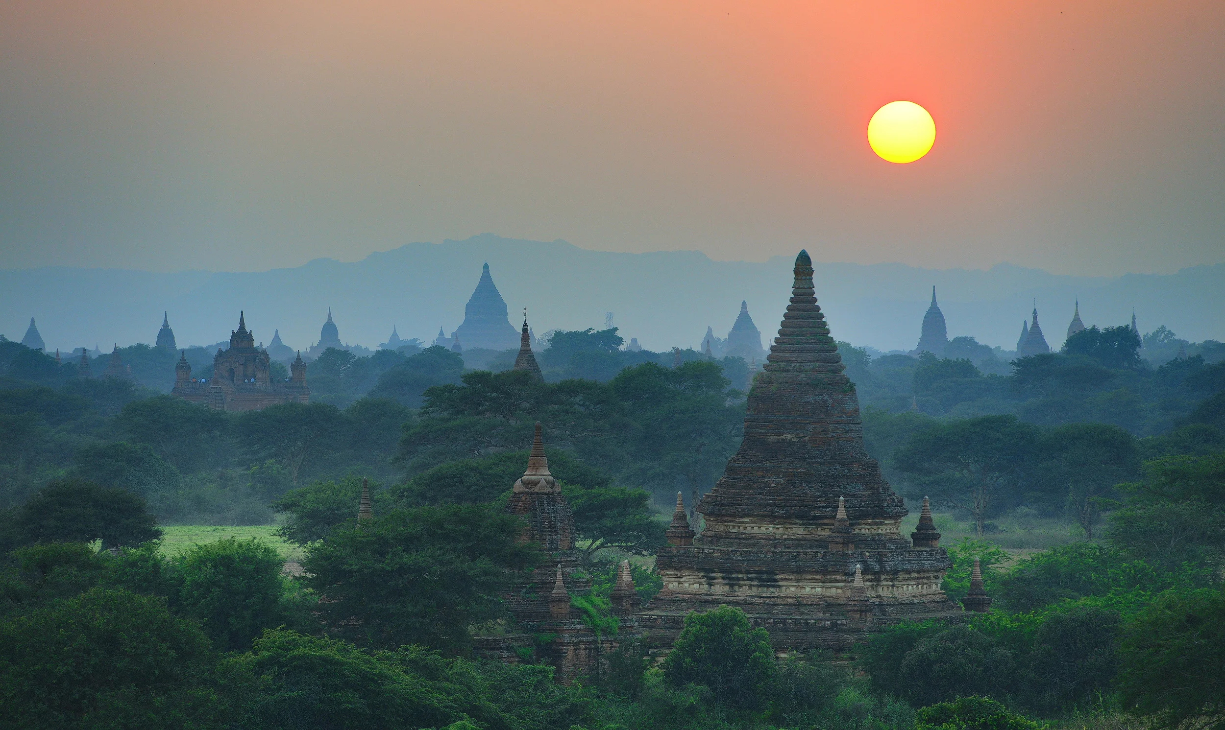 Bagan Sunset Sunrise is really the best time to photograph Bagan. There's usually a layer of mist on the plain, there are balloons in the sky, and you can find temple tops that are really quiet to set up and shoot from. However, as we were passing this temple on our bicycles as the sun got lower in the sky I decided I may as well have a walk up the steps and watch the sunset….and of course, as soon as I got there I couldn't resist taking a couple of frames. So this is the view from the top of Buledi temple as the sun sets in the west