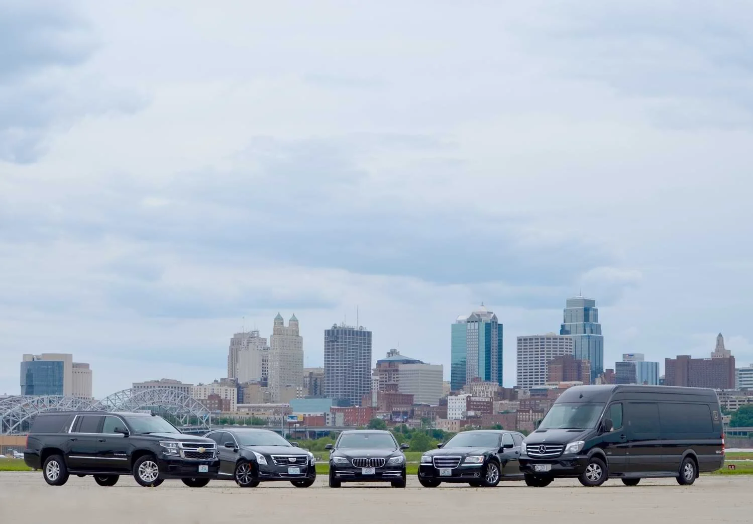 Various limousine type vehicles in front of cityscape.jpg