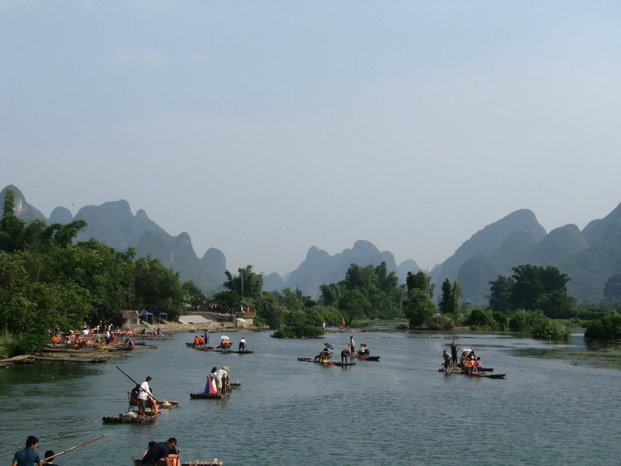 Take a leisurely Bamboo Raft down the Dragon River flanked by some imppressive karst mountains