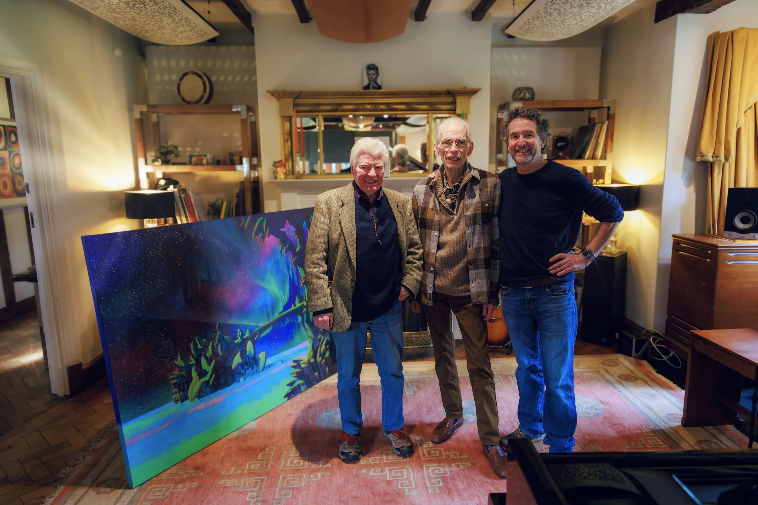 Steve Howe, Roger Dean and Curtis Schwartz standing in Curtis Schwartz Studio beside the original artwork for YES’s forthcoming album Aurora.