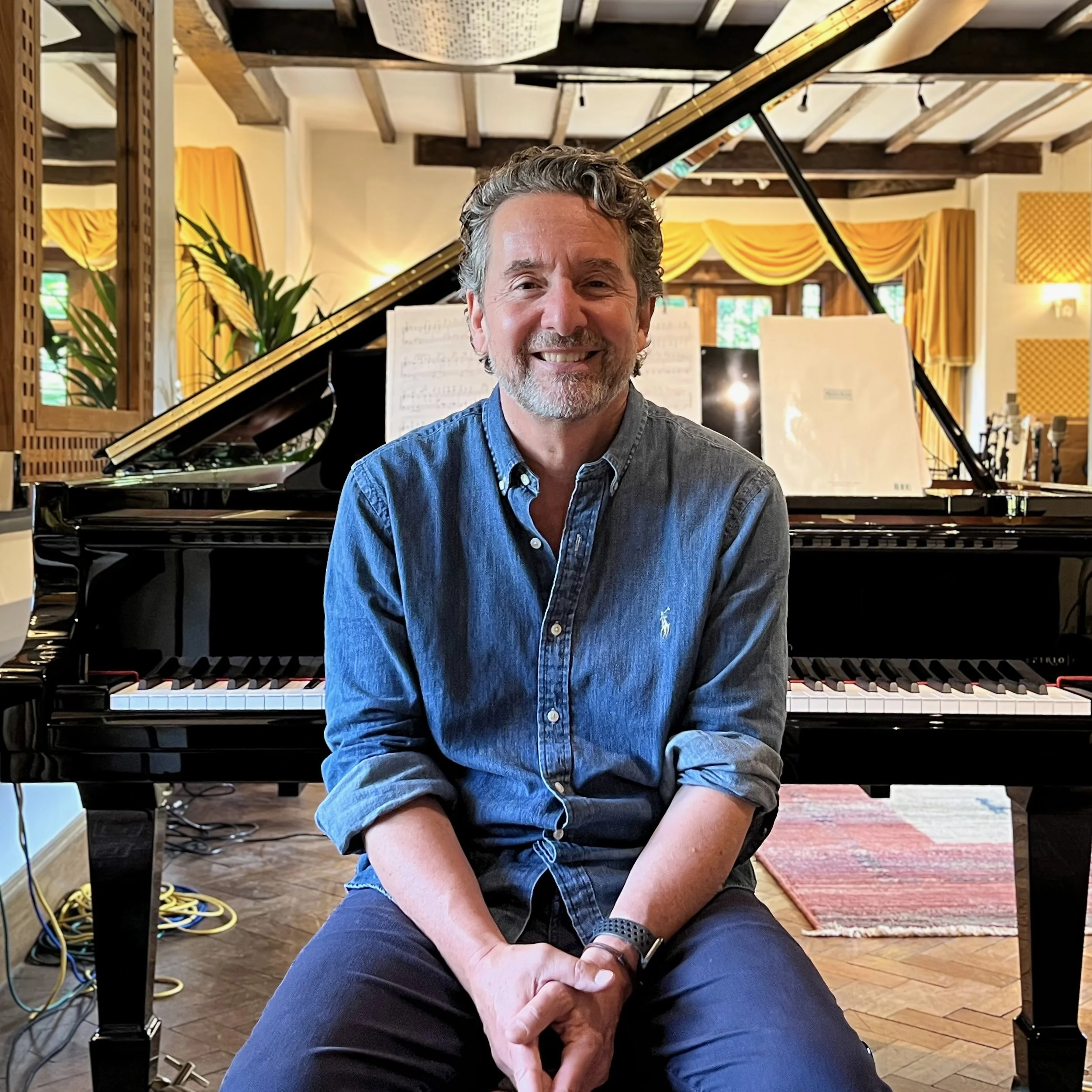 Curtis Schwartz, composer and songwriter, seated at a Steinway grand piano in Curtis Schwartz Studio.