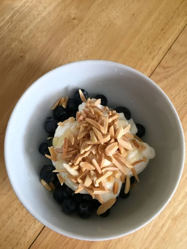 Outside of just washing some off and eating them plain, this is my favorite way to enjoy blueberries, topped with greek yogurt and some toasted slivered almonds with a drizzle of honey. As a dessert, think about a "dessert flip", instead of ice cream with berries on top, reverse it. Try 1/2-3/4 cup of blueberries topped with a couple small spoonfuls of ice cream and some sliced almonds and coconut shreds.